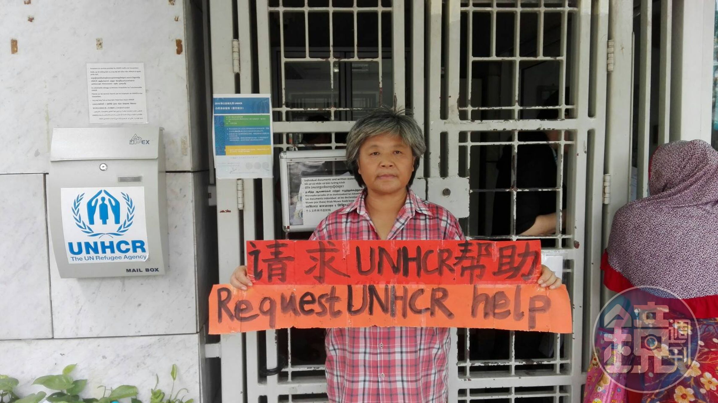 滯留曼谷的中國籍難民張淑鳳，在聯合國難民署前舉牌，抗議未受到妥善安置，並希望能引起往來官員的注意。（攝影：Jack Huang）