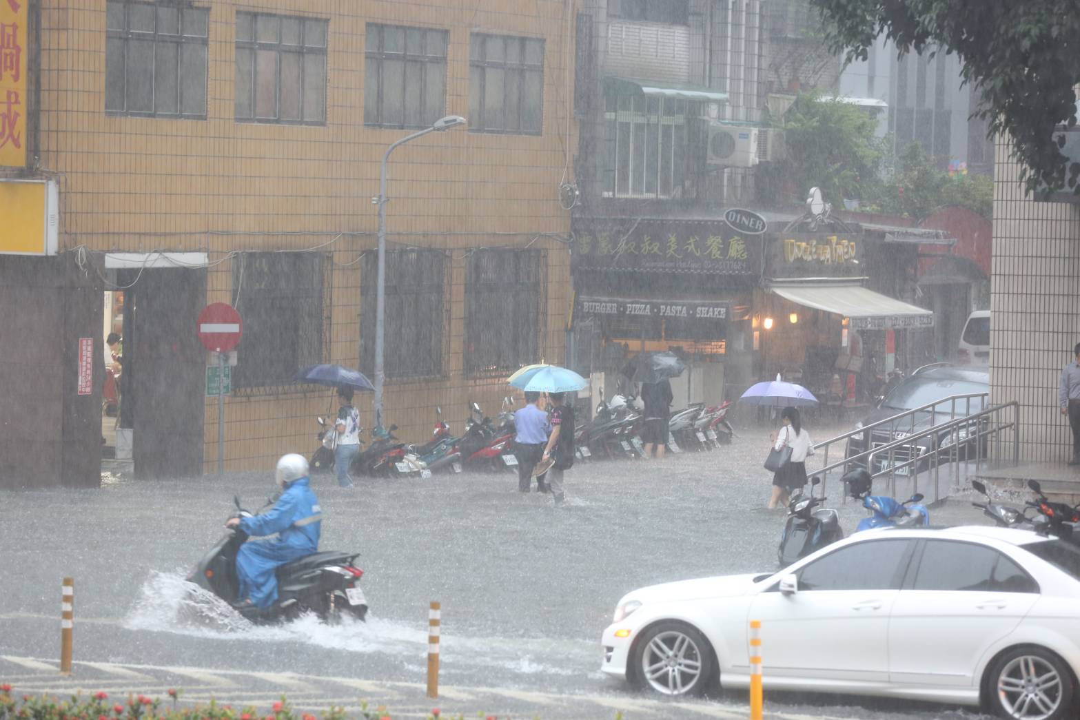 眼看雨越下越大，水淹及膝，還是有民眾在雨中涉水前進。