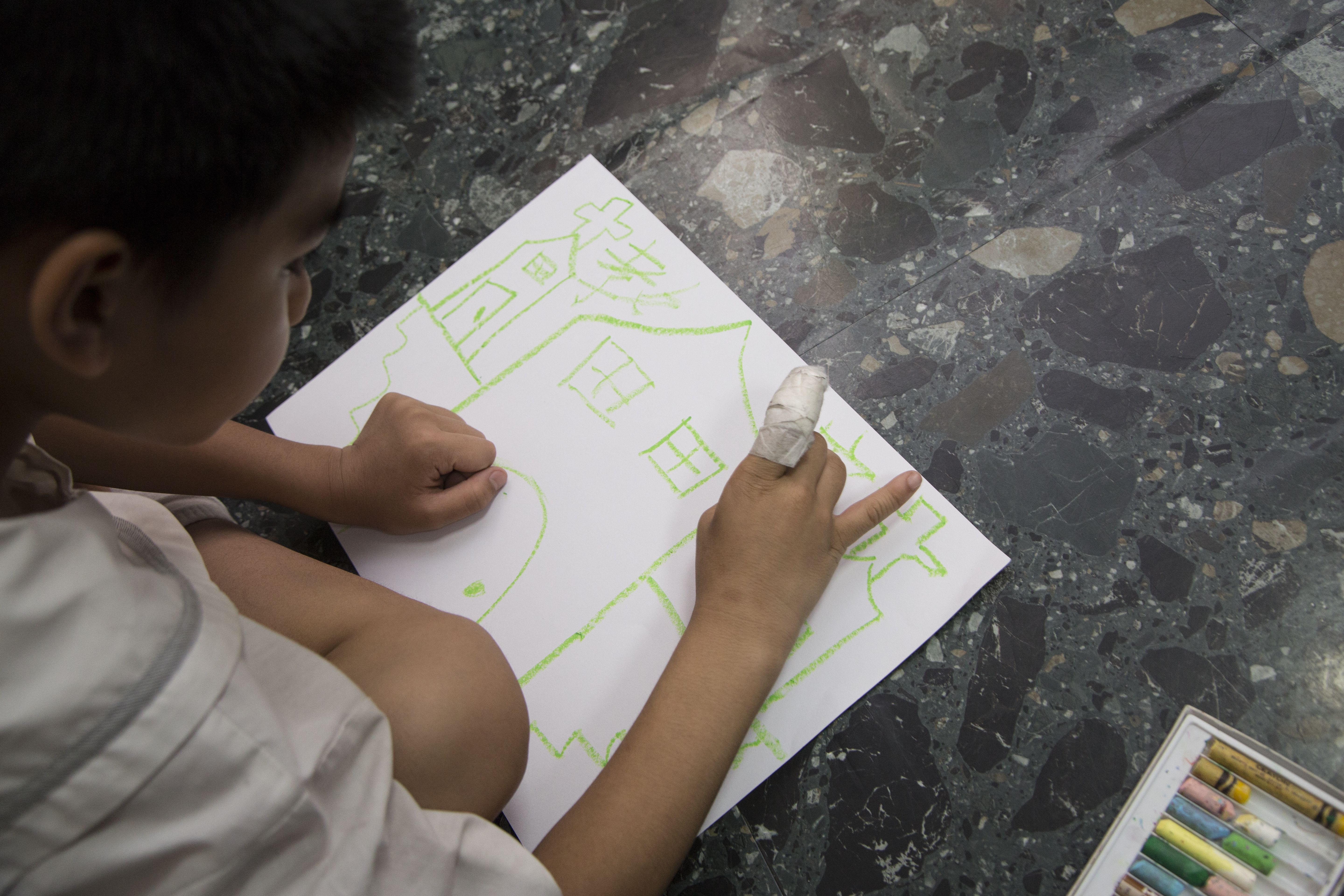 小飛的手指雖然受傷了，但仍開心地畫畫。