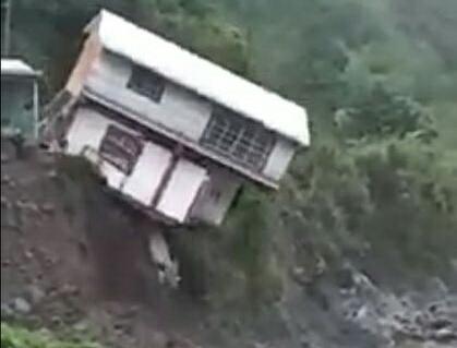 因岸邊地基被大水衝擊、全部掏空，鐵皮屋正往溪谷墜落。