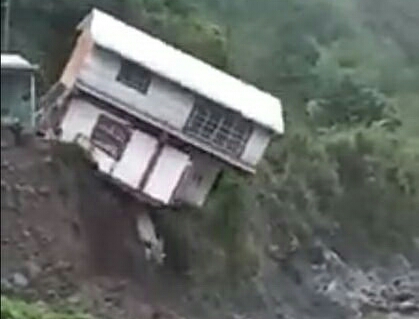 因岸邊地基被大水衝擊、全部掏空，鐵皮屋正往溪谷墜落。