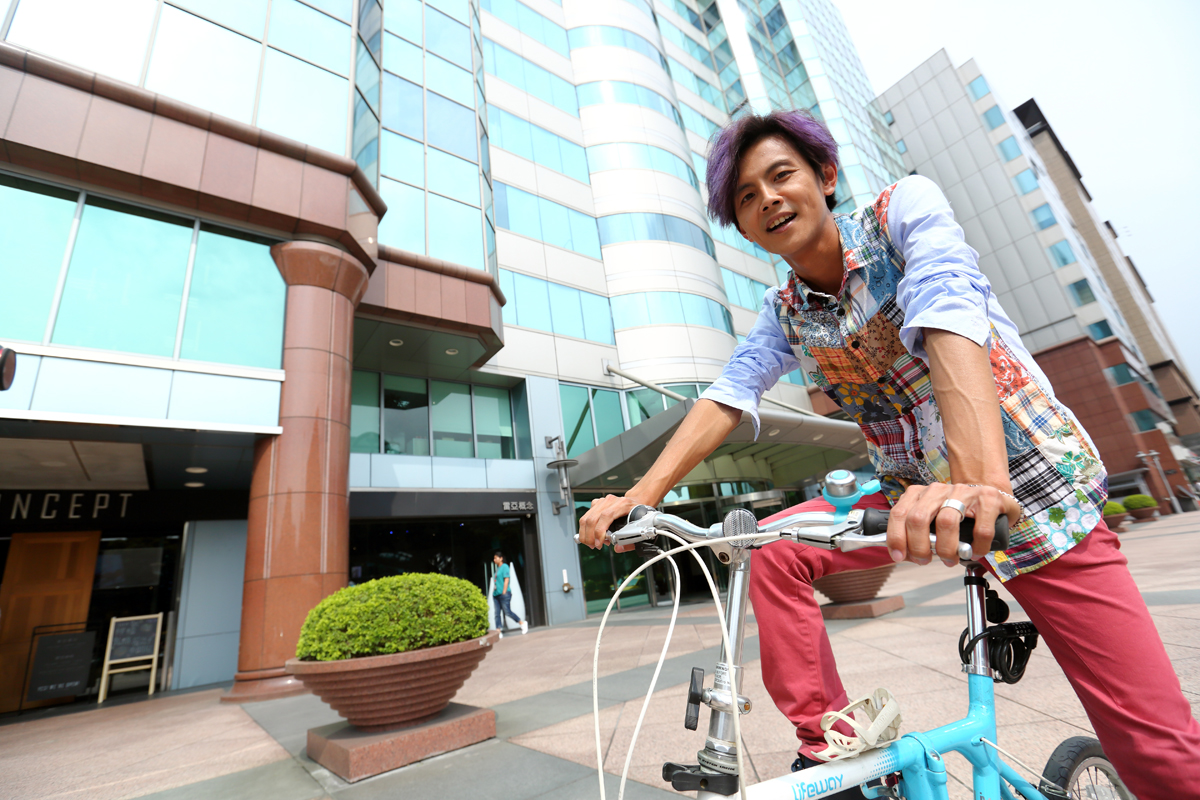 阿翔在台北市區跑通告，不開寶馬大車，愛騎鐵馬。