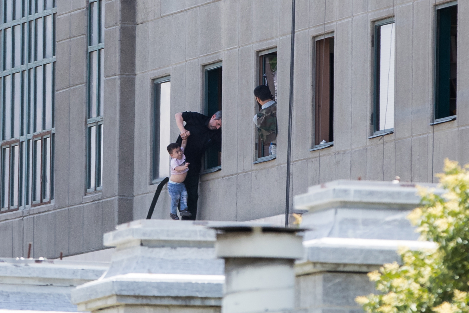 伊朗國會大樓發生恐怖攻擊，伊朗警方協助受困民眾與兒童撤離。（東方IC）