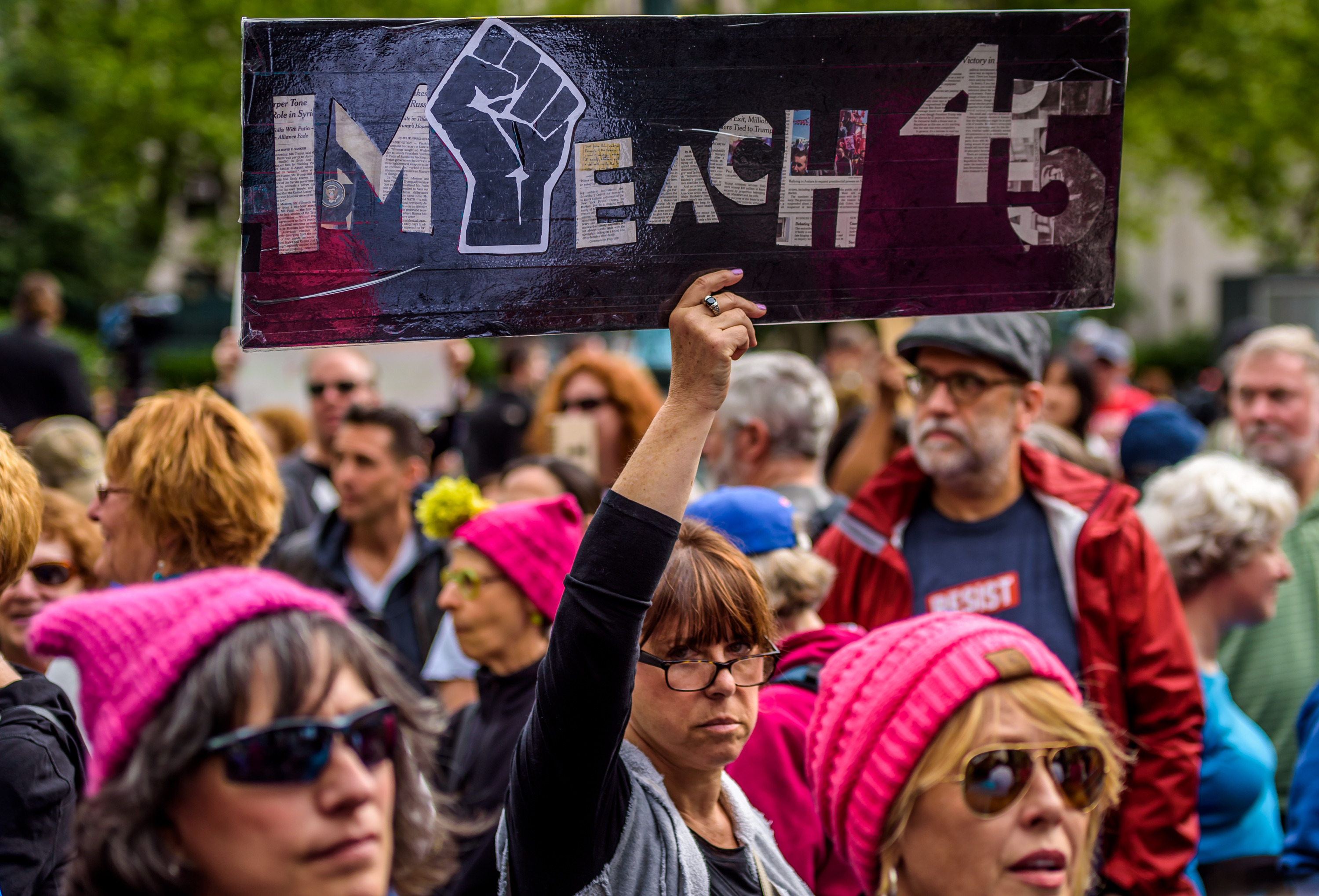 日前紐約一場「真相大遊行」中，抗議民眾高舉「彈劾45任總統」的標語。