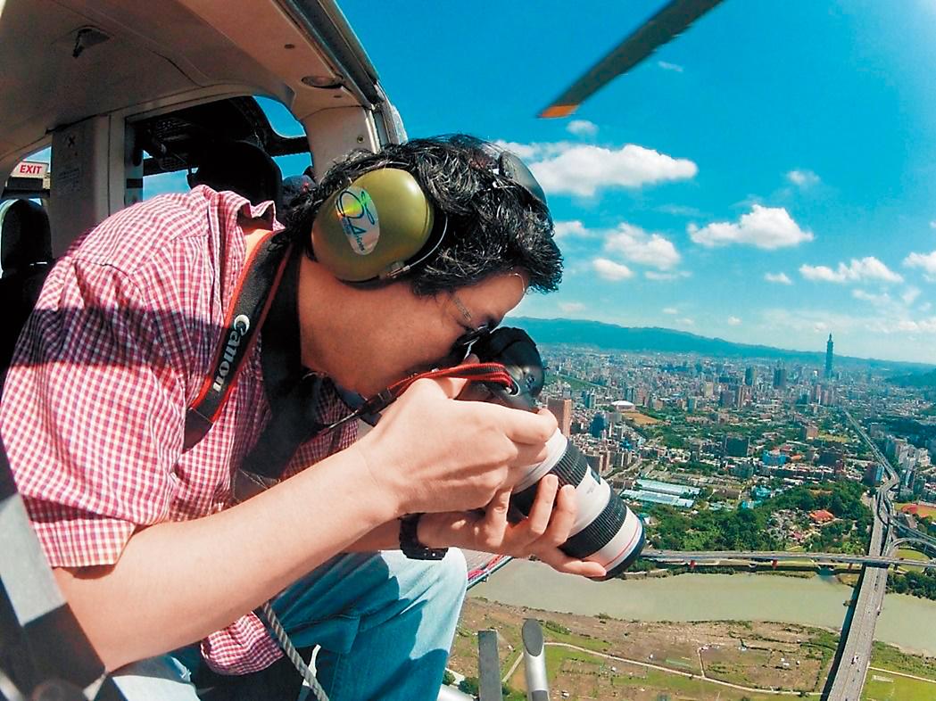 齊柏林常這樣持著相機，靠腳和背維持平衡拍照，全身就只靠一條安全帶綁住腰身。（台灣阿布電影公司提供）