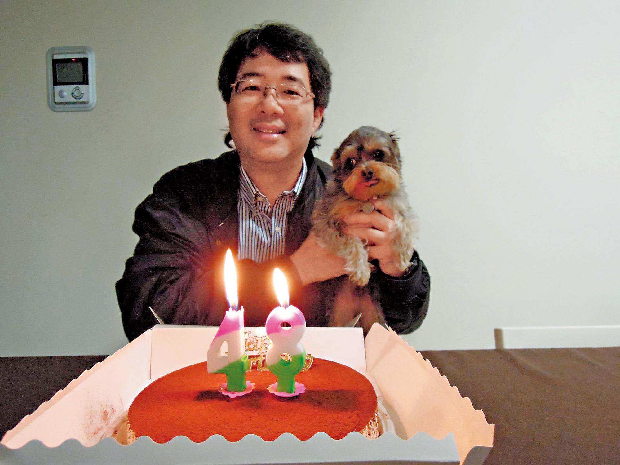 齊柏林很喜歡動物,這是他48歲時生日的照片,手上的狗是公司集體認養的寵物。(翻攝《齊柏林的飛閱台灣》)