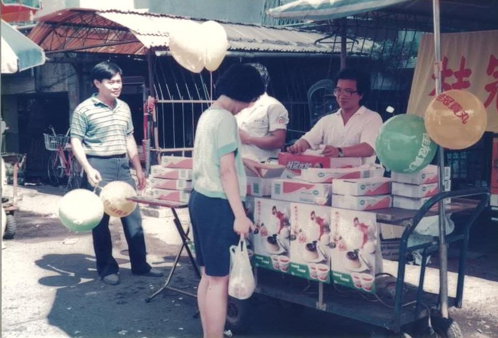 1988年,王正明帶著公司員工在菜市場推廣桂冠水餃,標榜買3盒送1顆海灘球。(桂冠提供)
