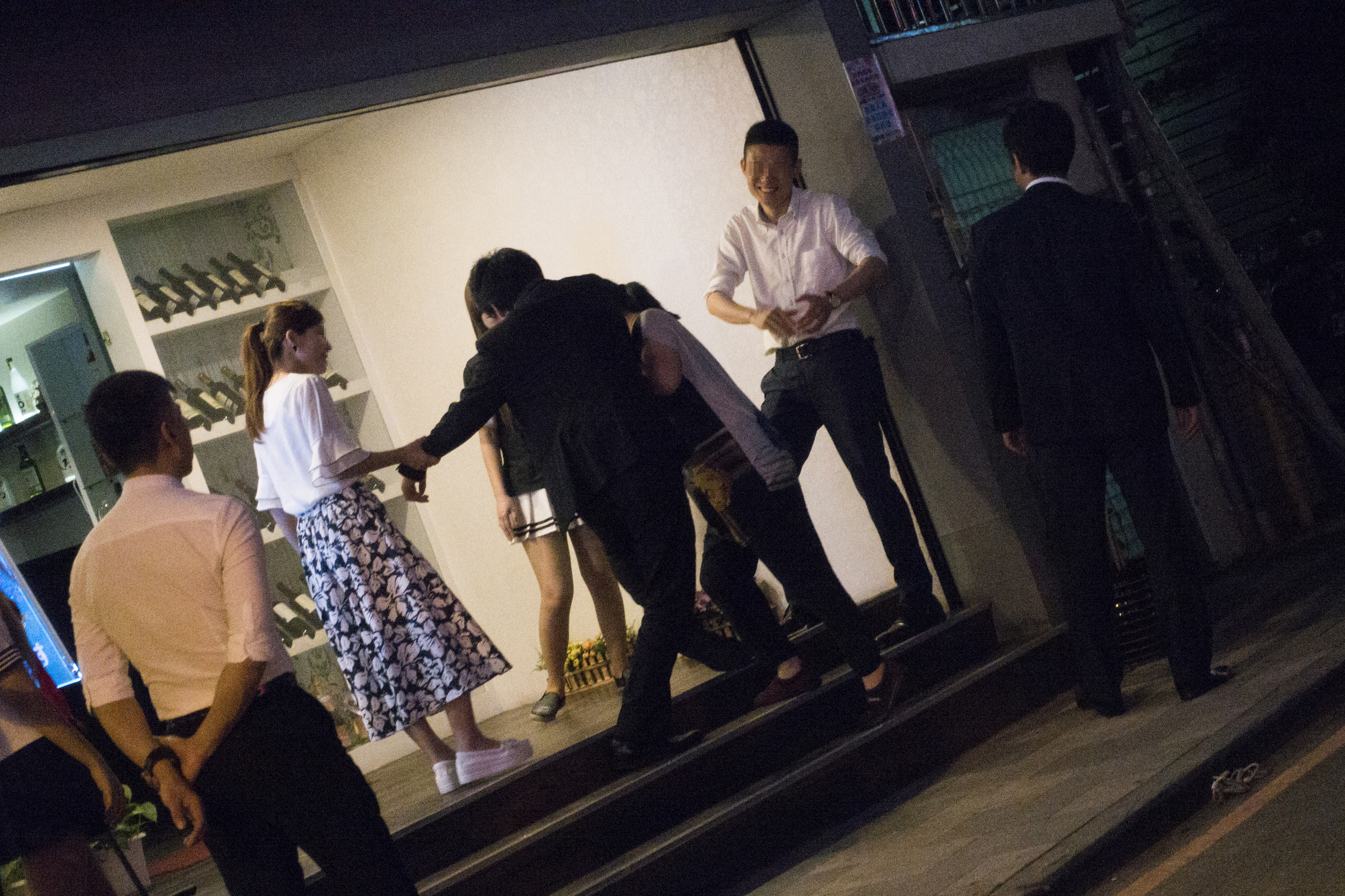 日式酒店前一群準備離開的日本客人酒醉被小姐攙扶著。