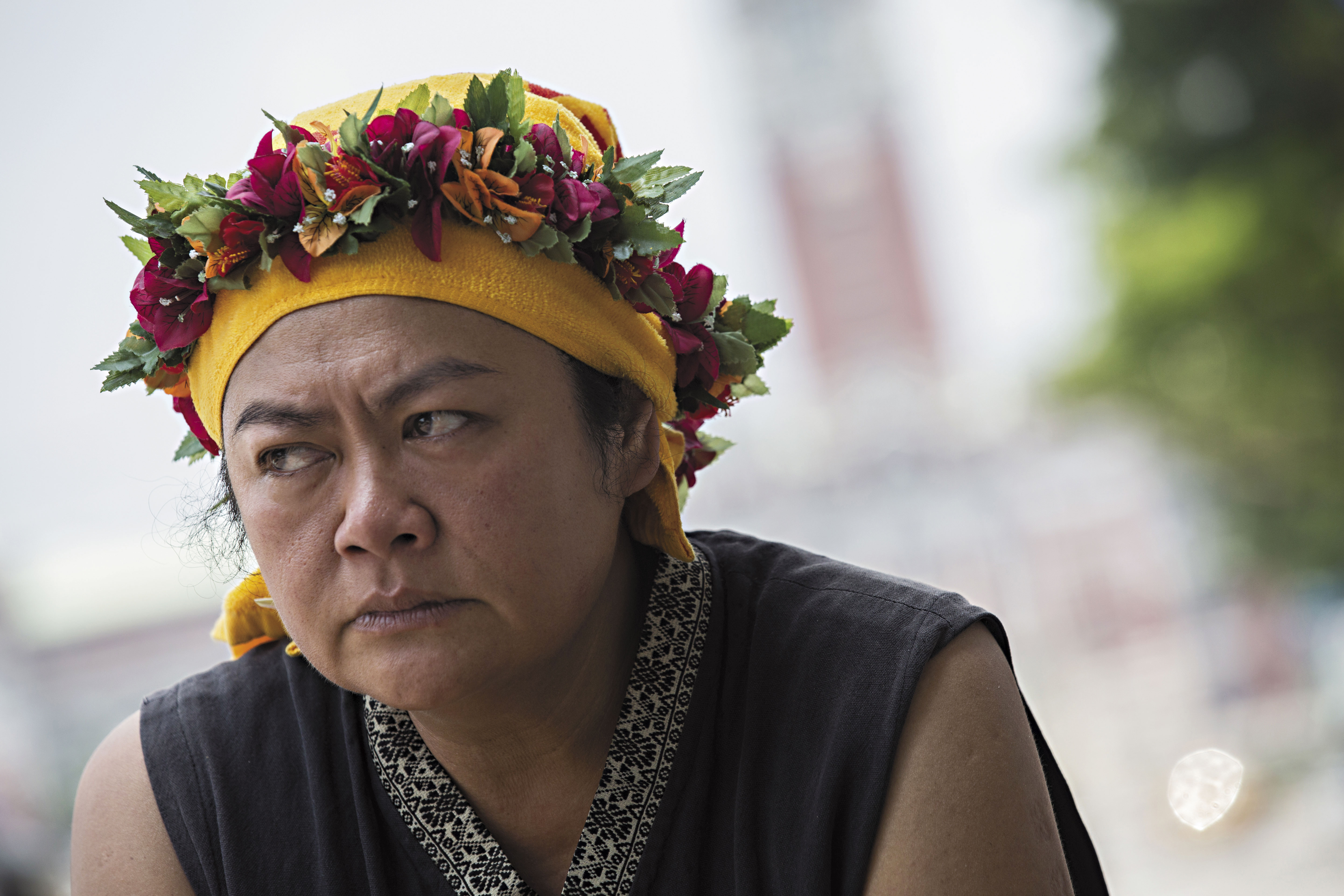 巴奈在總統府前的凱道上接受採訪，她穿著部落傳統服飾，頭戴友人獻上的花環，但烈日下她的神情甚是疲憊。