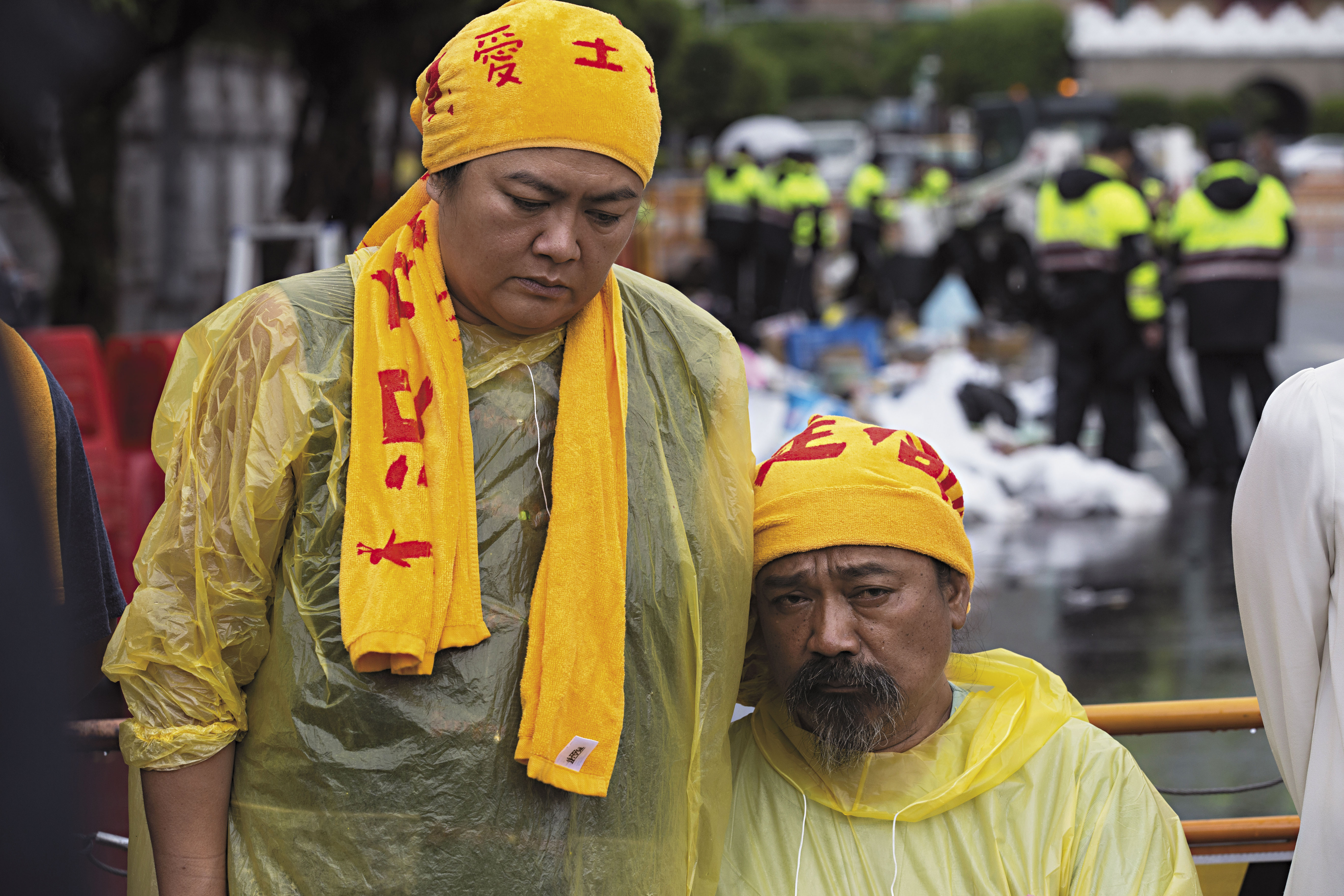 6月2日的清場日，巴奈（左）和伴侶那布（右）始終相依，他們在大雨中神情落寞，身後是被警方拆除後聚集成堆的藝術品和物資。