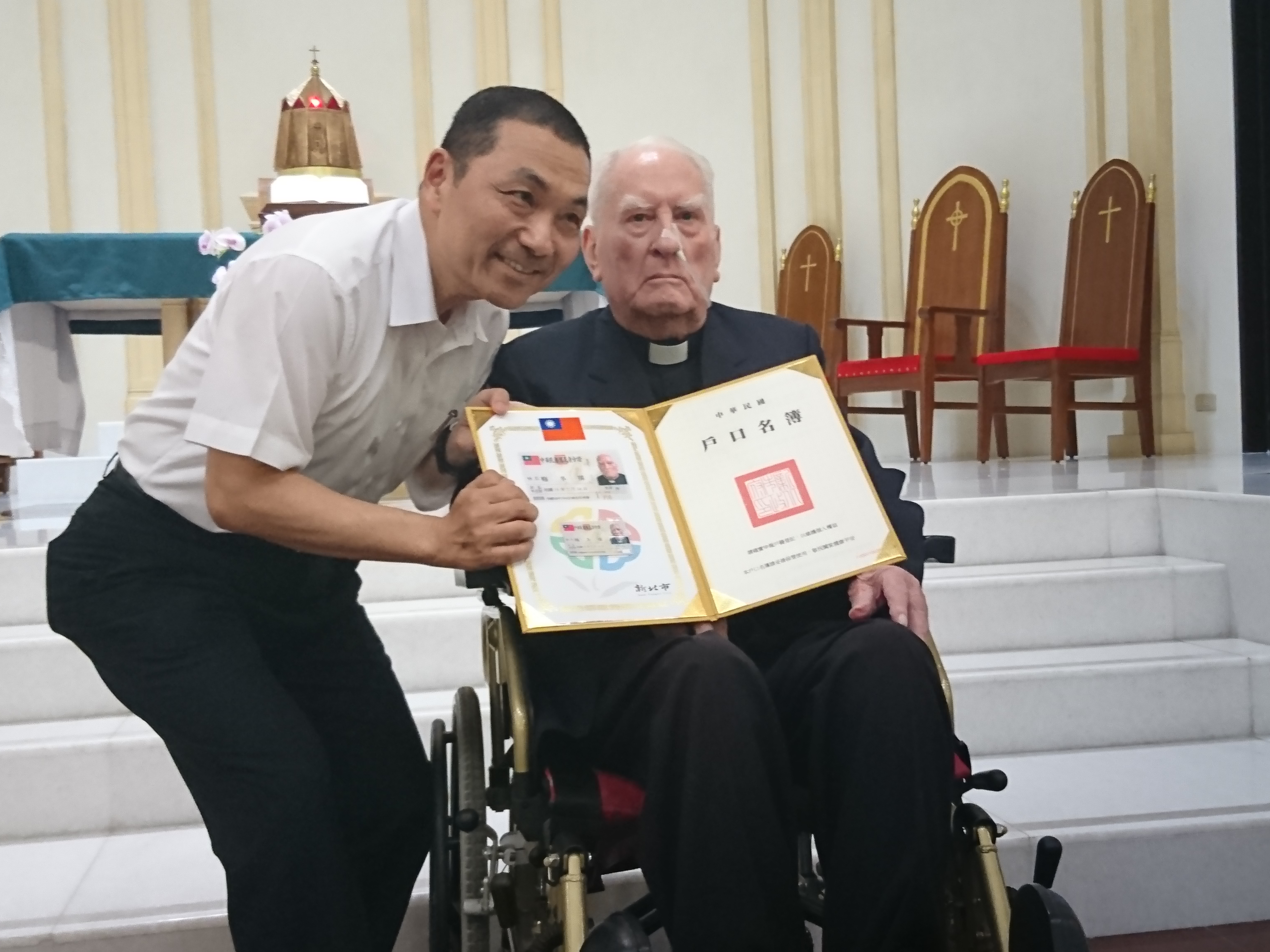 4日從侯友宜手中接過身分證，梅冬祺神父激動不已。