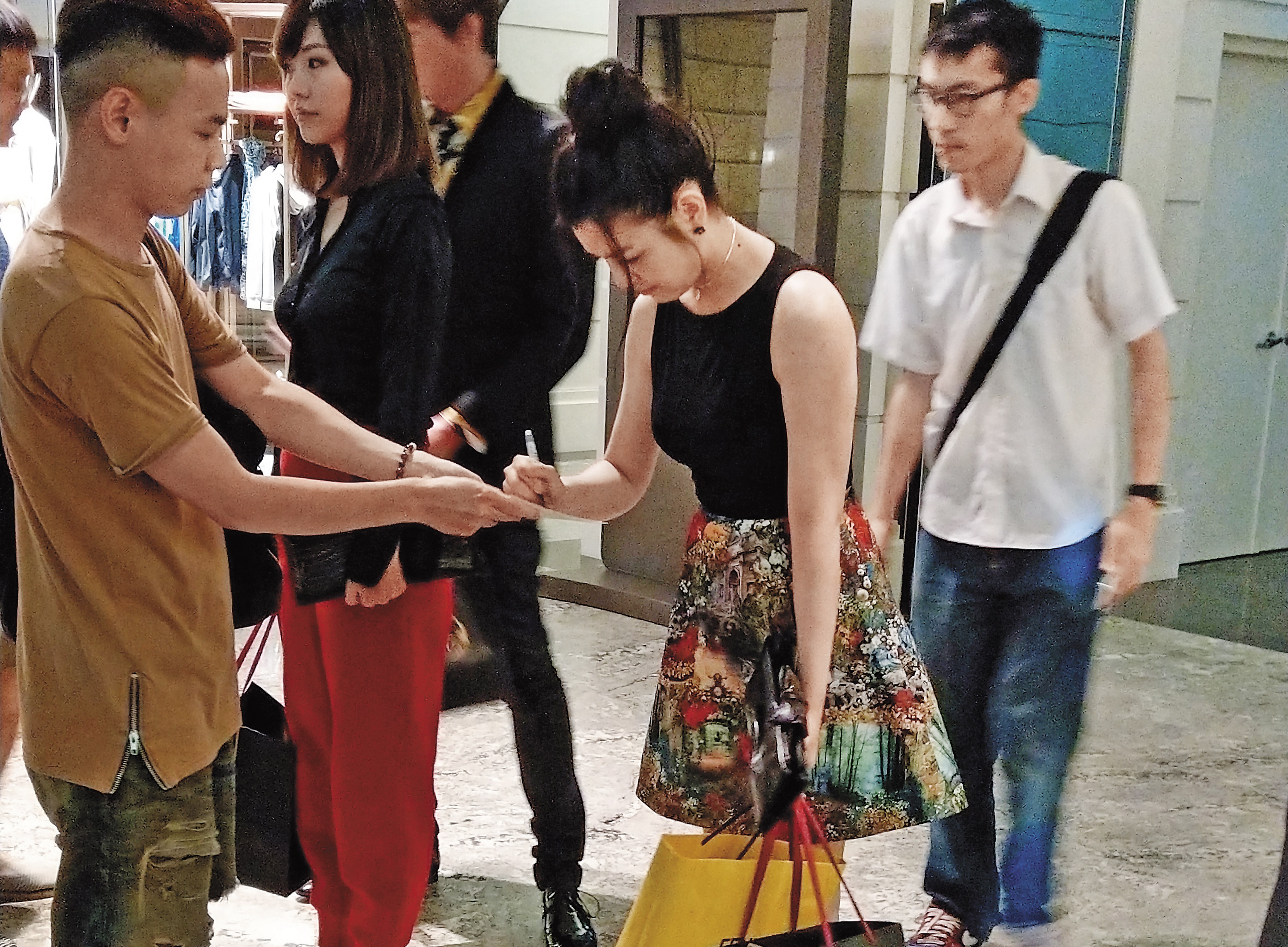 陳妍希一手提著滿滿的袋子，一手幫粉絲簽名，非常親民。