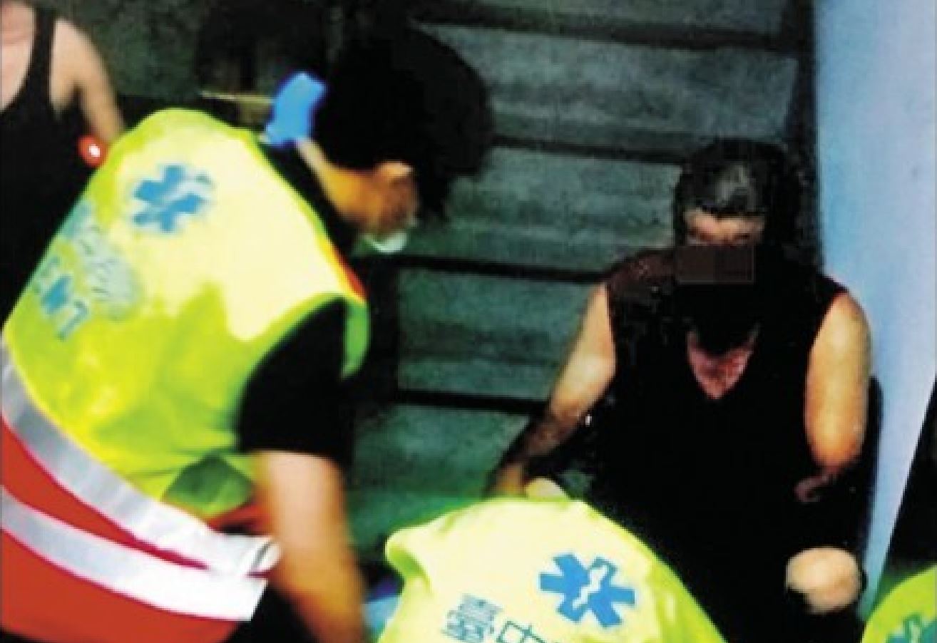 警消獲報，趕到現場搶救昏死在地的陳妻，陳嫌則面無表情，呆坐一旁。