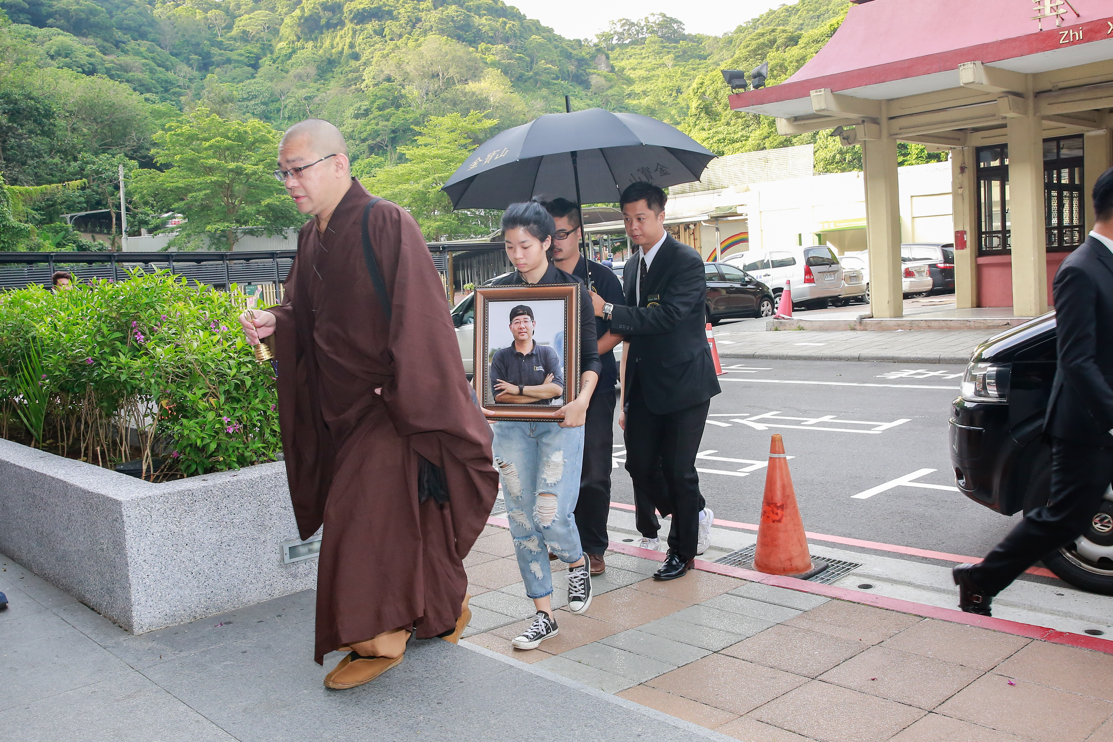 齊柏林的兒女捧著父親的遺照及骨灰罈抵達。