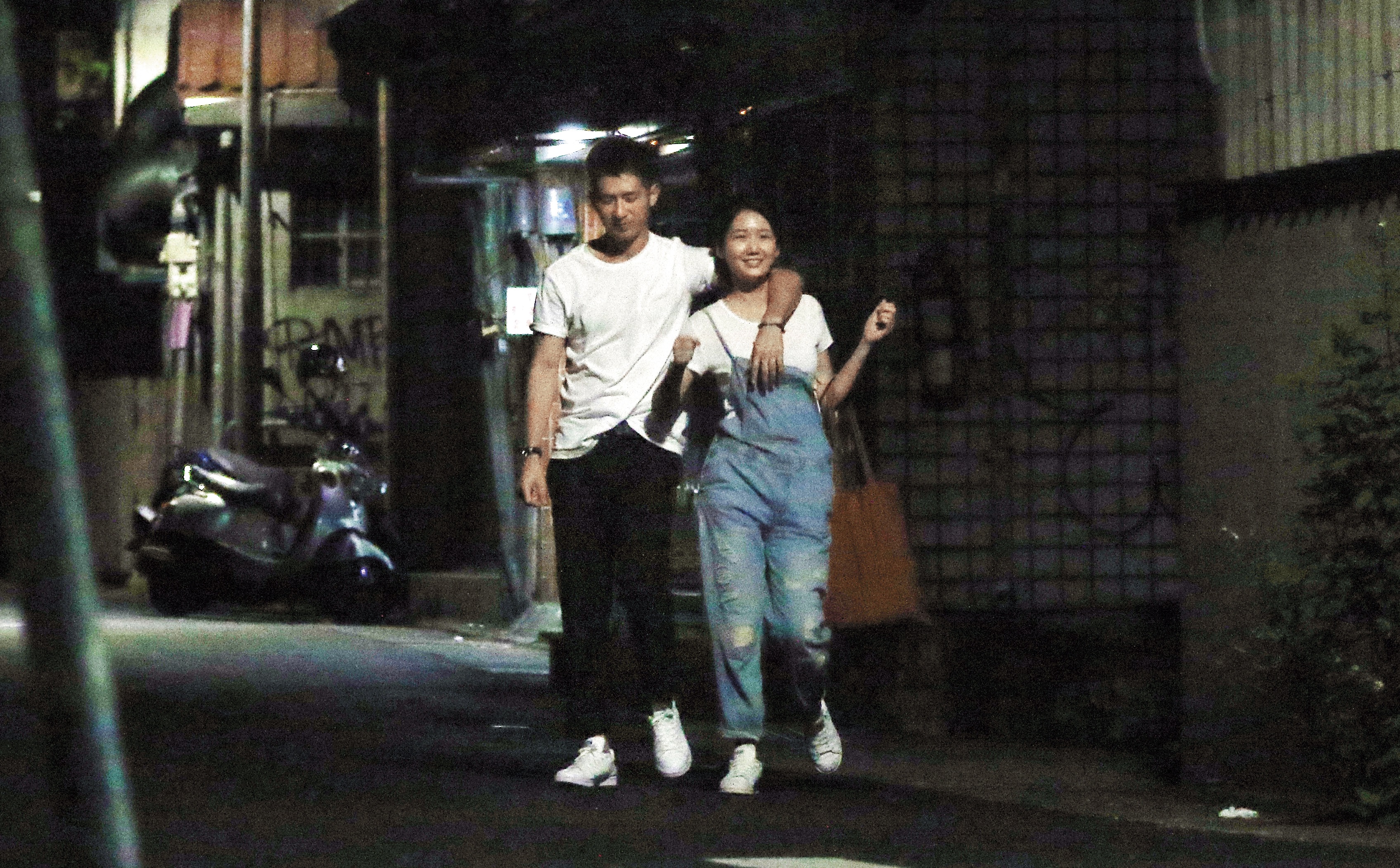 喝醉的簡宏霖（左）在女友攙扶之下步出KTV，女友看他喝醉還樂不可支。