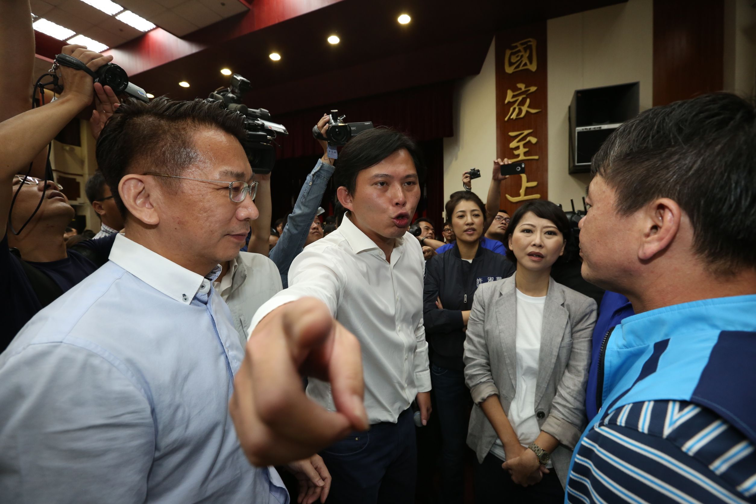 黃國昌要求官員上台備詢，但發言台被國民黨立委佔領，他便前往與國民黨團溝通。