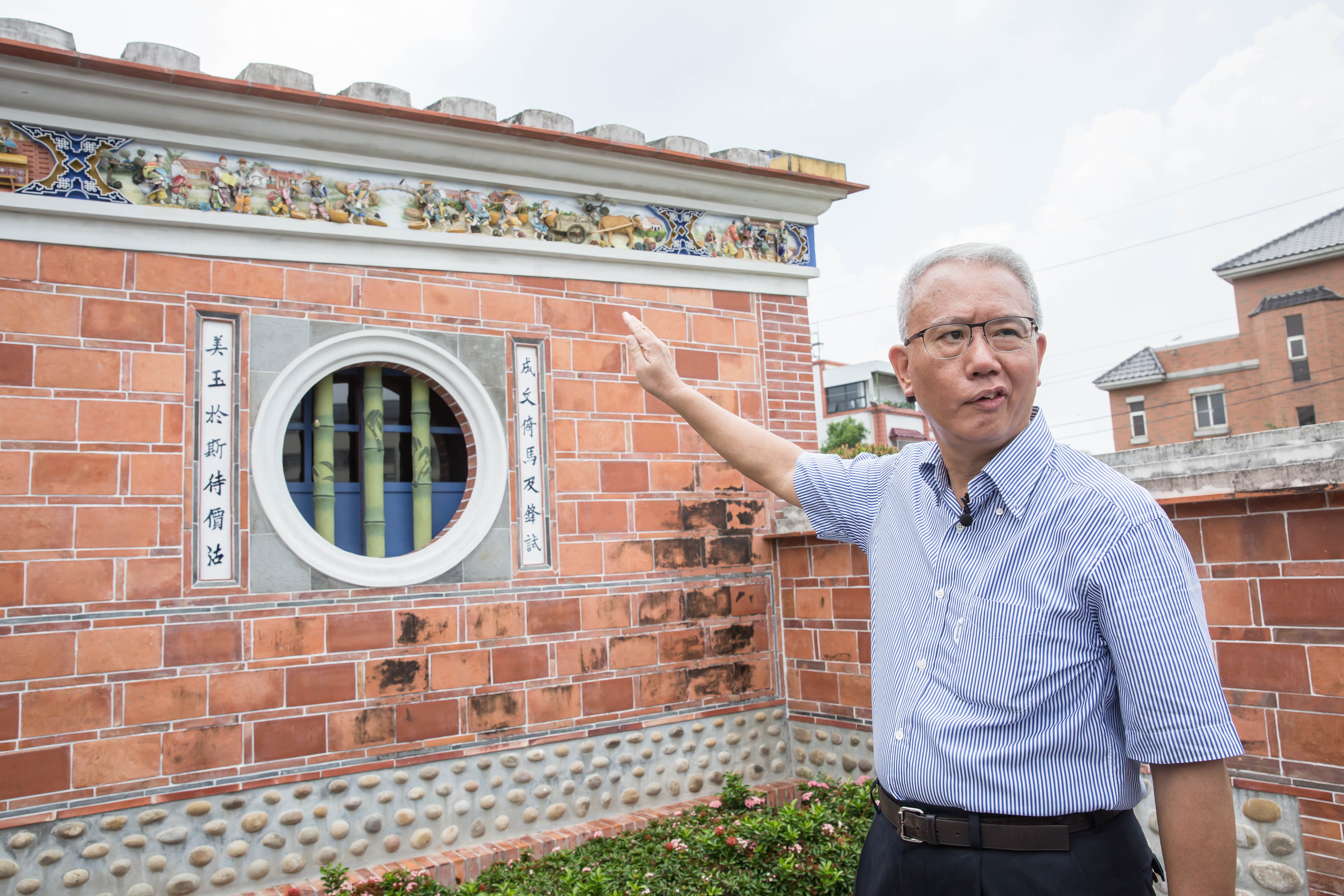 魏應充指著園區的建築，認真地解說成美堂的文化意象及工法。