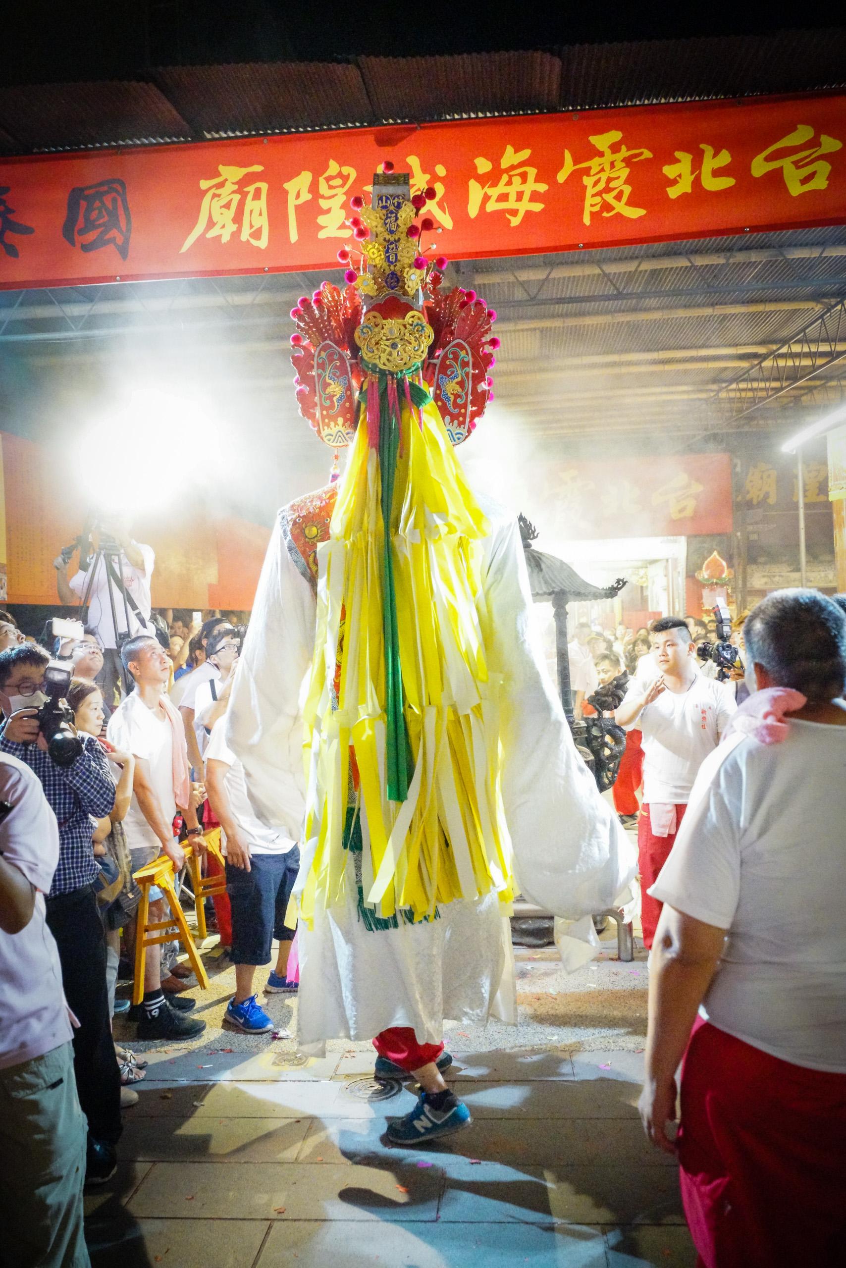 身材高大的七爺進廟，必須蹲低身體，對操控神將的人來說是一大考驗。