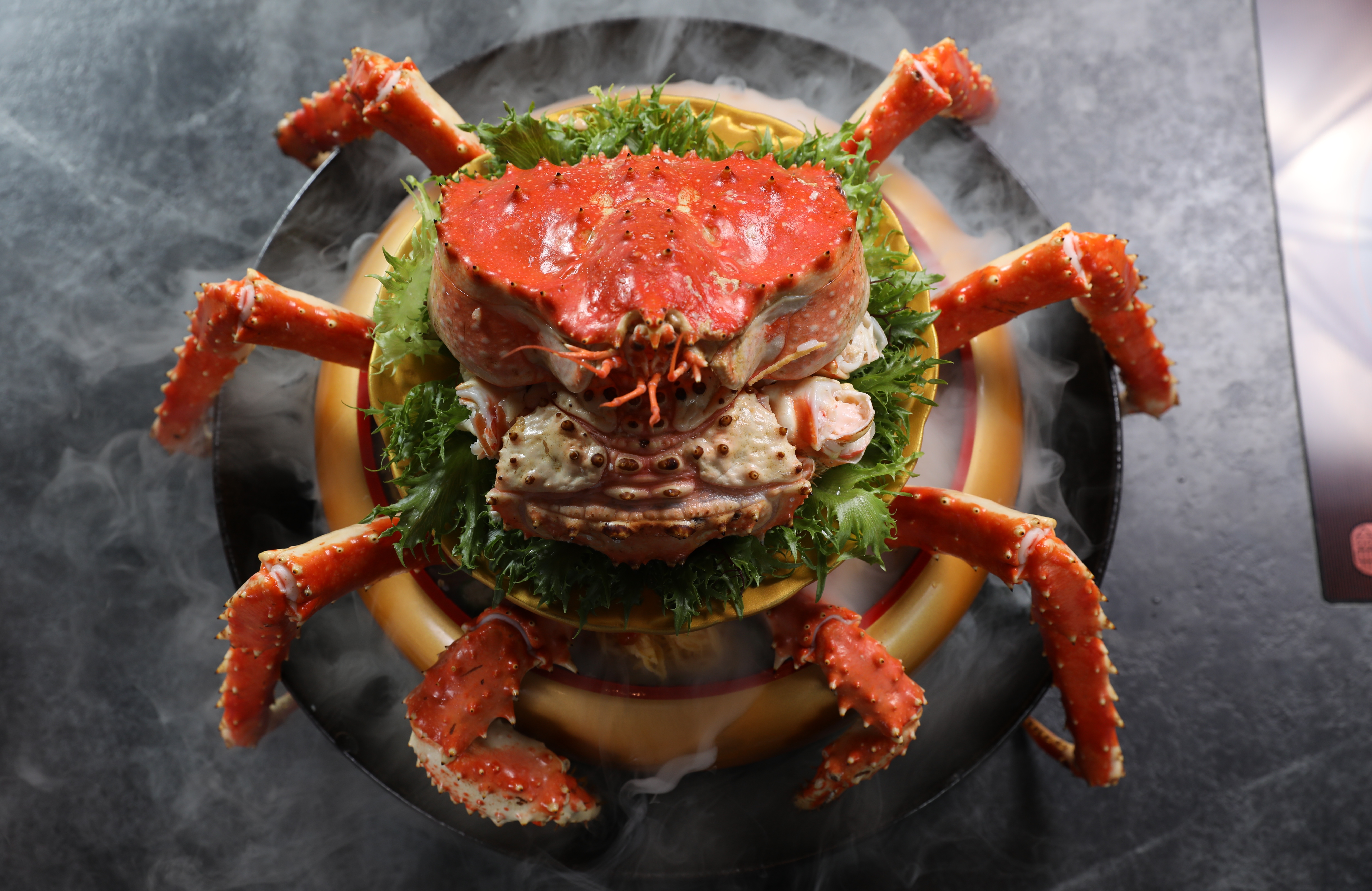 「帝王蟹蓋飯」噴著乾冰上桌，視覺效果足以震撼老爸。（時價，約580元／100g，圖中約1,000g、5,800元）