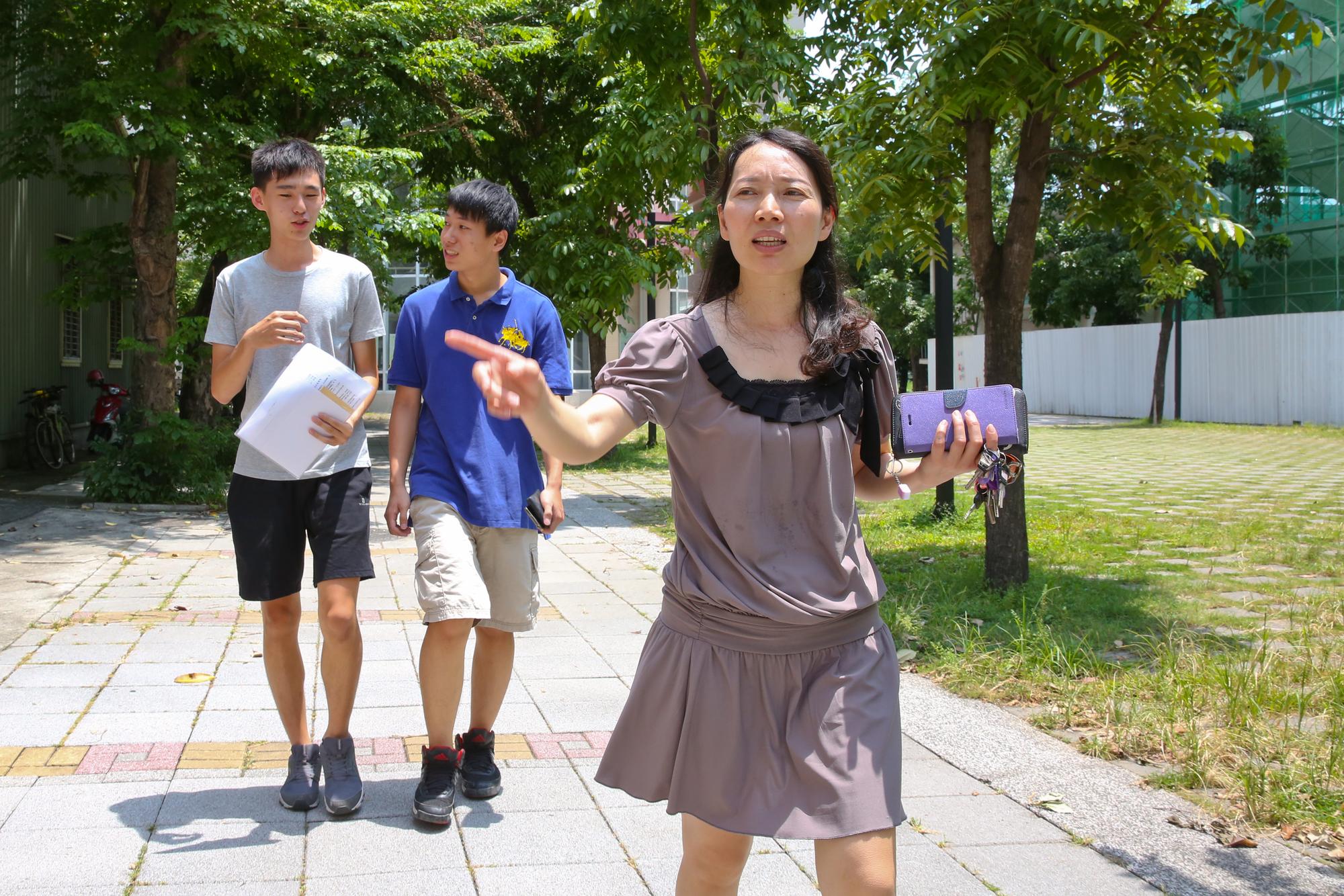 數學老師黃惠玲帶著畢業生走在校園裡,她不擔心學生的賺錢力,只提醒學生要有理財力。