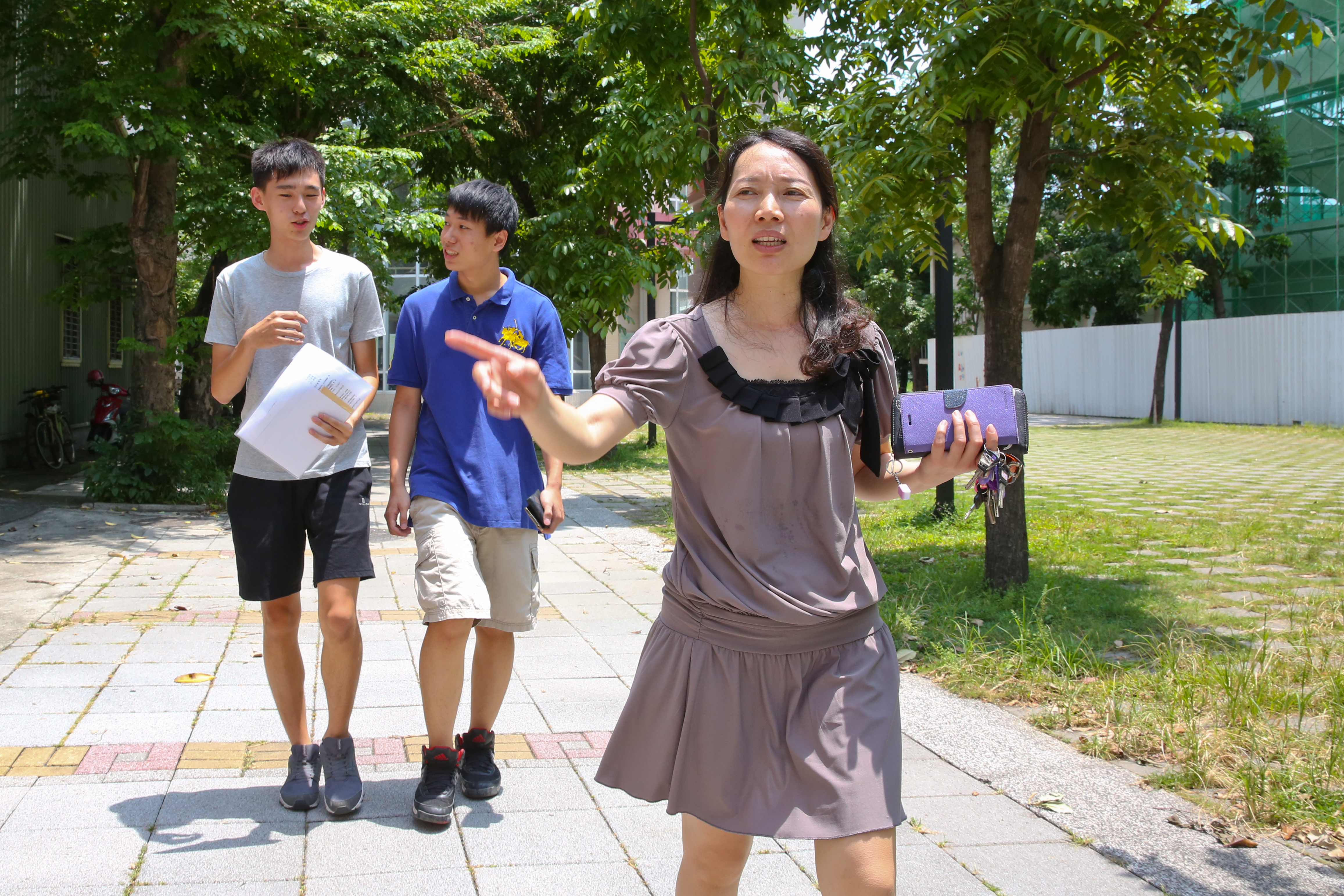 數學老師黃惠玲帶著畢業生走在校園裡，她不擔心學生的賺錢力，只提醒學生要有理財力。