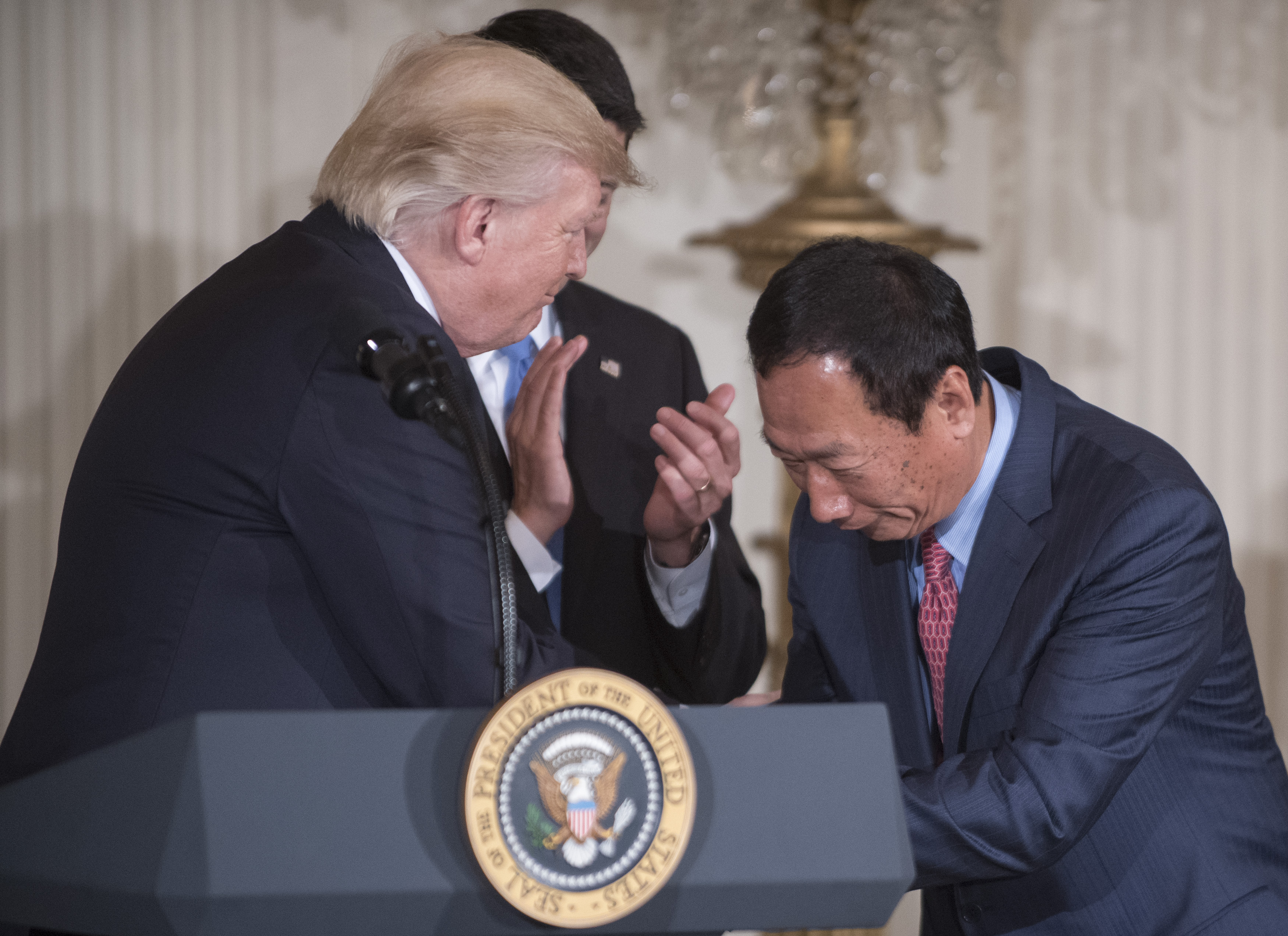 研究顯示，與層峰交好有助於企業股價表現。圖為26號鴻海董事長郭台銘赴白宮與川普握手。（東方IC）