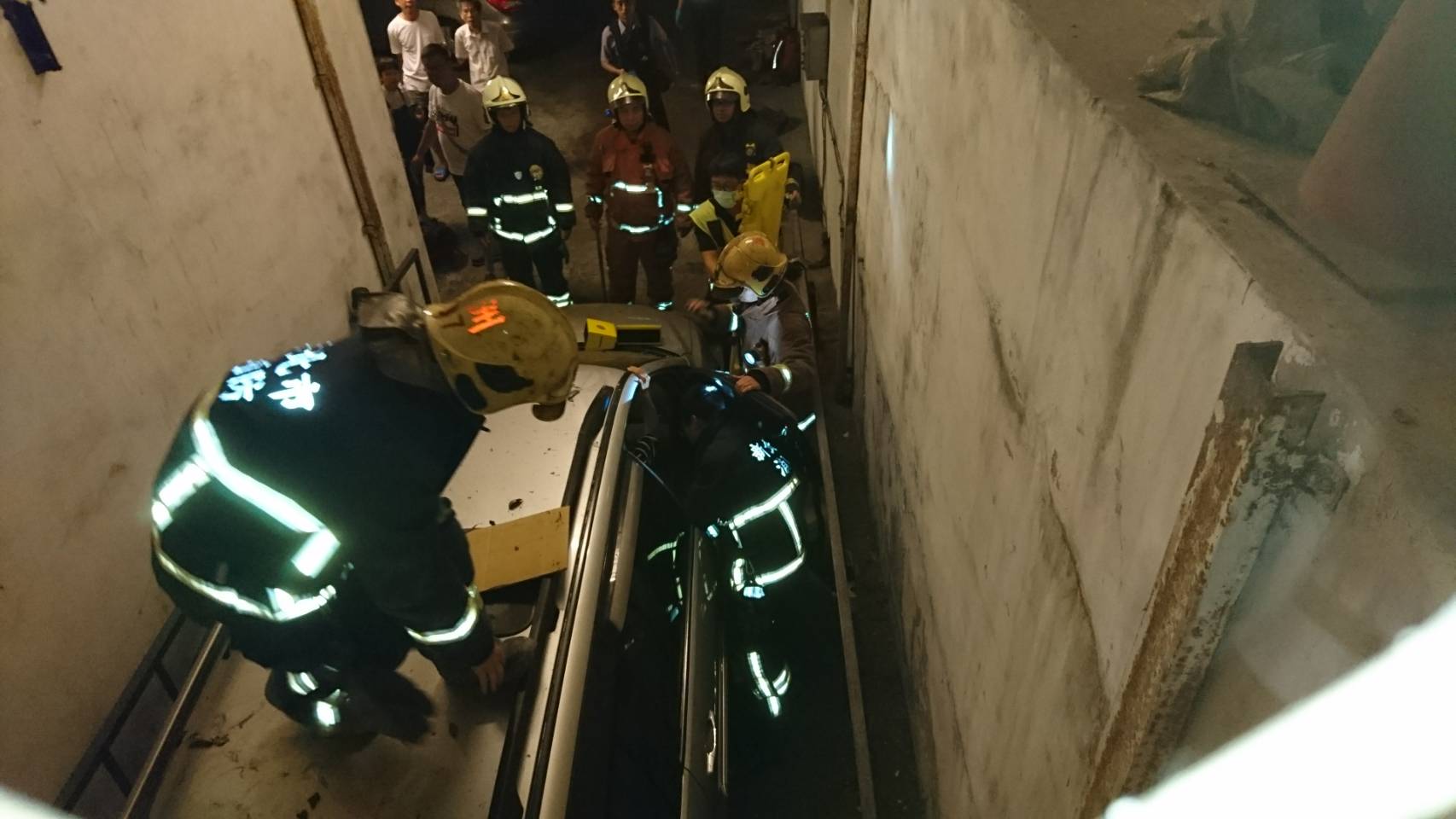 由於現場空間狹窄，消防人員必須爬上休旅車才能操作脫困器、長背板等工具。（翻攝畫面）