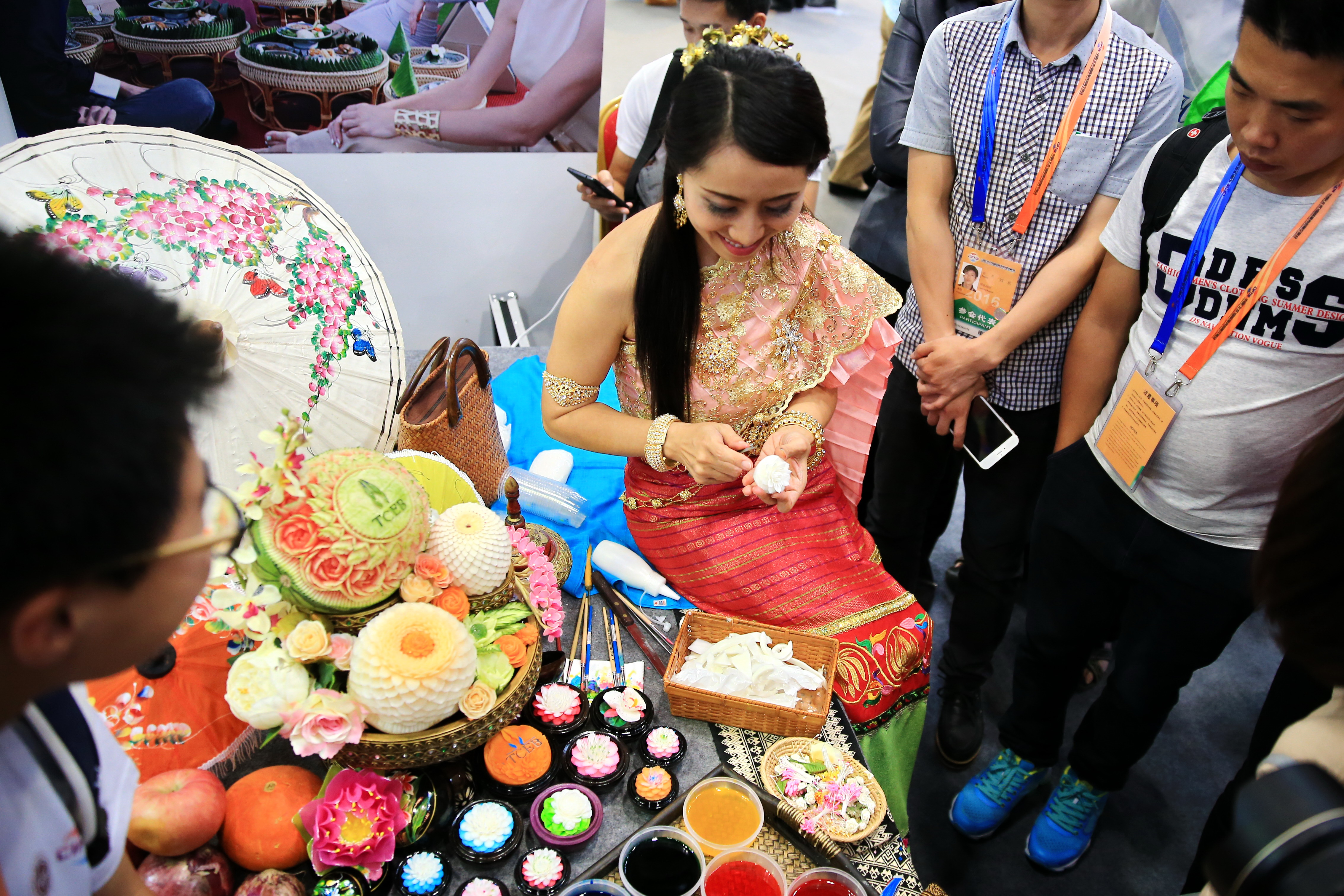 一位泰國美女，在2016年的北京服務貿易交易會現場進行蠟燭刻花表演。（東方IC）