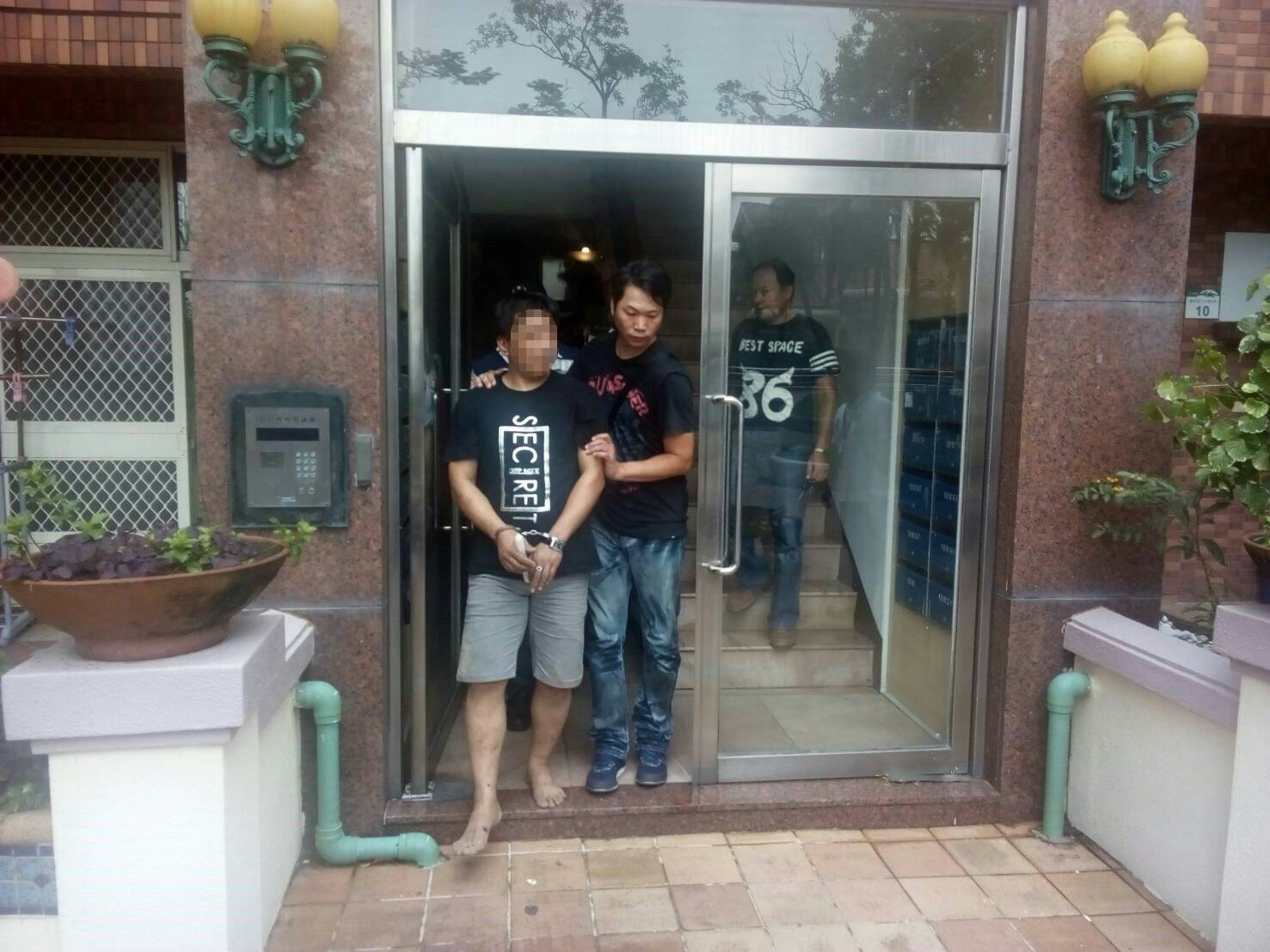 警方逮捕暴力毒品黑吃黑集團，為首的何姓男子因為與警方駁火太緊張，臉色慘白的走出大樓。