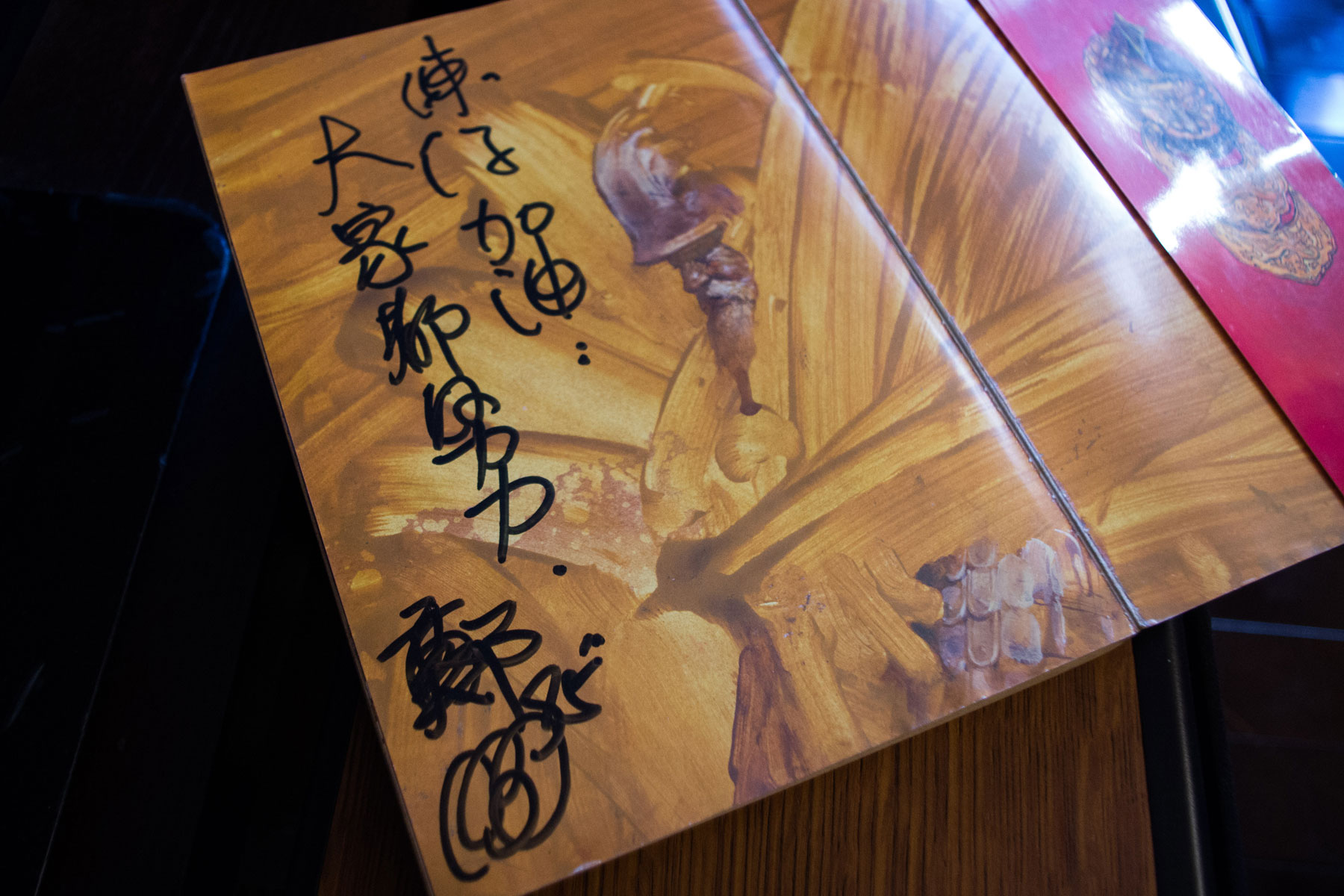 鄭問在書上題字鼓勵練任。練任笑說，老師每次簽書送徒弟，寫的都是「加油」，鼓勵大家繼續創作。（周文凱攝）