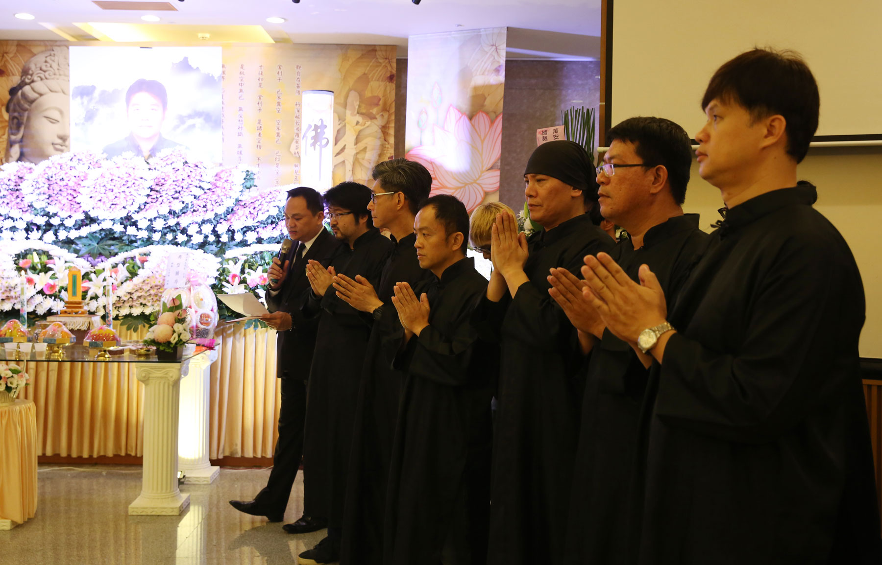 鄭問告別式會場上，徒弟、助手齊聚，與家人一同穿孝，送恩師最後一程。（陳毅偉攝）