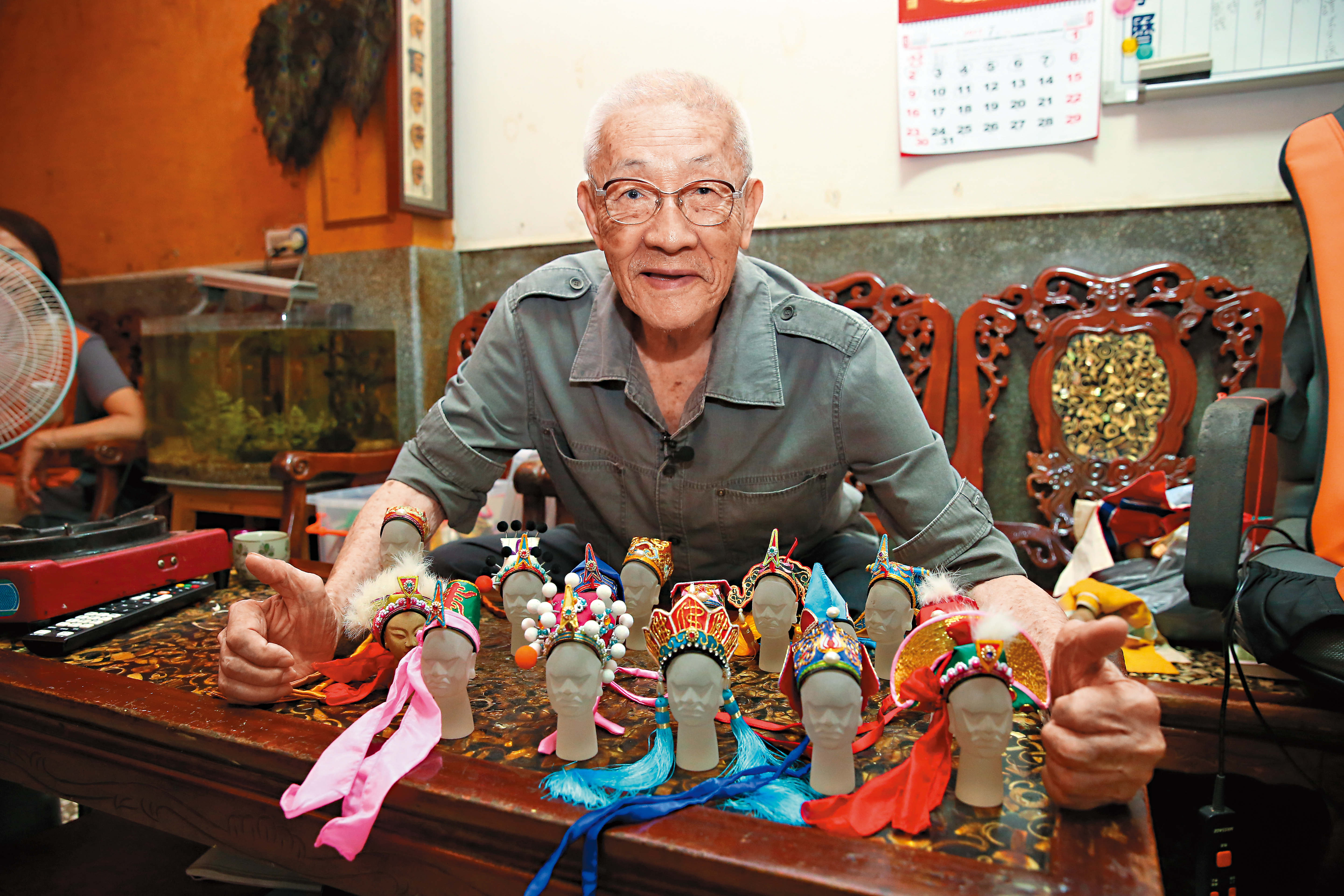 陳錫煌親手縫製的頭盔帽飾講究精美,拍照時他調皮地說:「都是我的。」