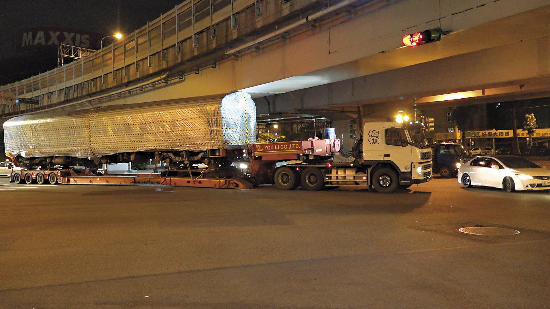 上週二晚間10點,車廂吊掛至拖車上後,趁著深夜台北市區車輛較少時運送至桃園,運送過程一度卡在高架橋下。