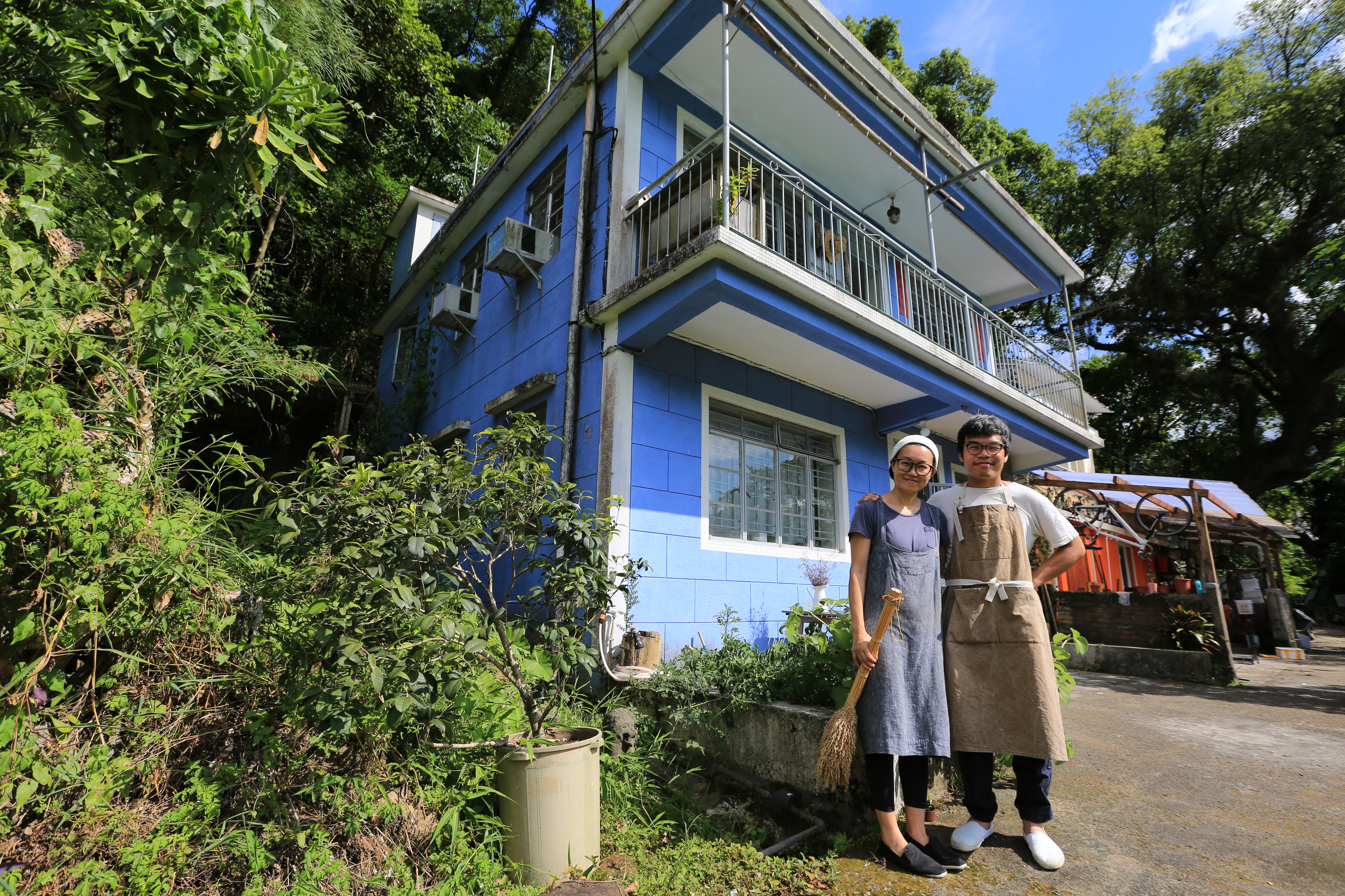 何比與陳達燊在身後的藍色小屋裡過起理想的小農生活，在香港是非常難得的一件事。