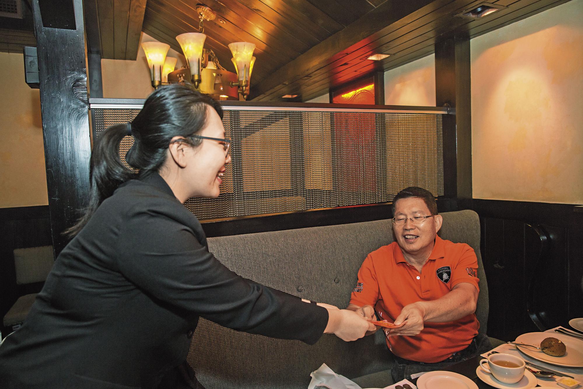 黃有忠(右)隨身帶彩券,餐廳服務生服務態度周到就送一張彩券。