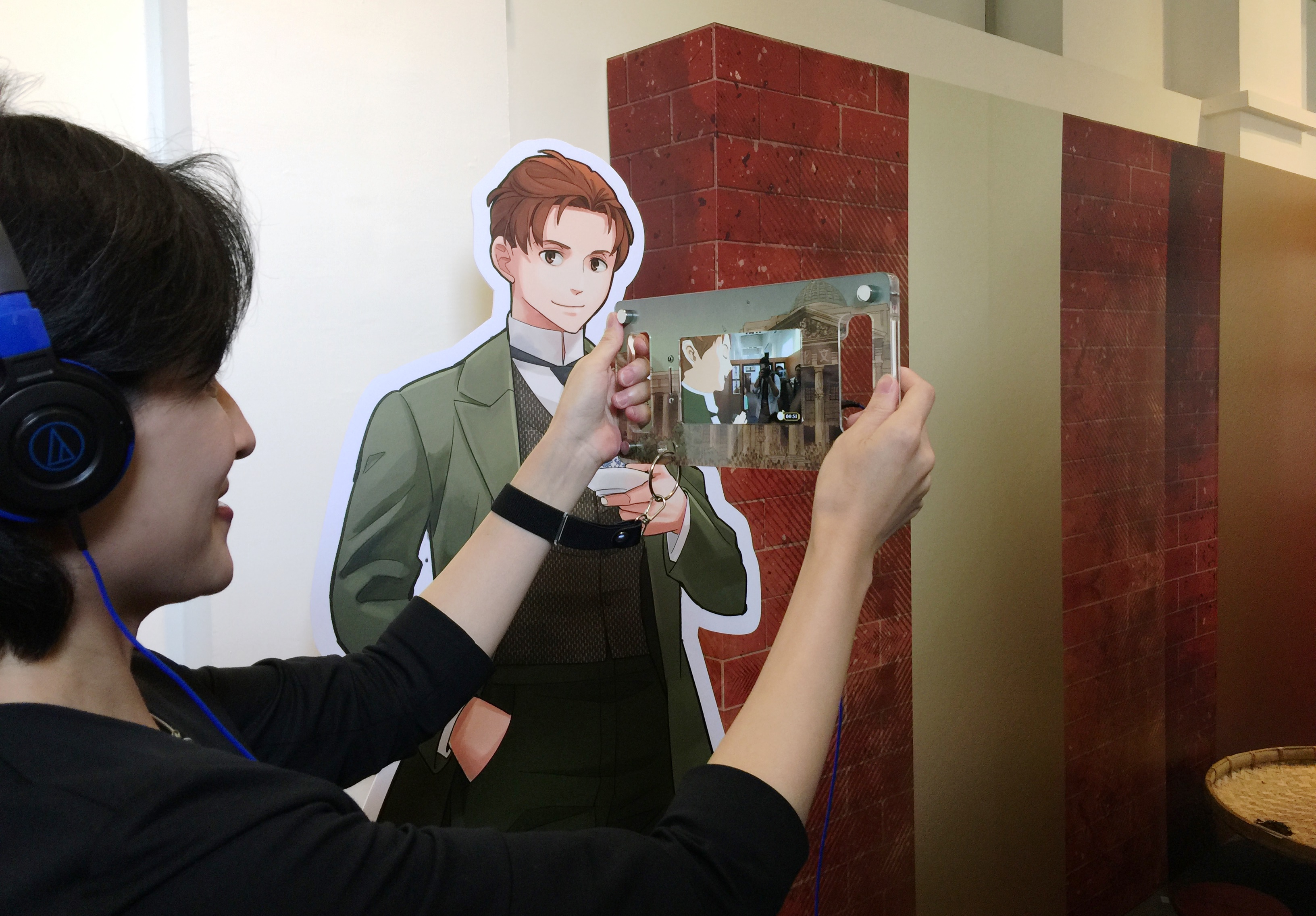 文化部長鄭麗君手持AR，由漫畫人物自己介紹展品。