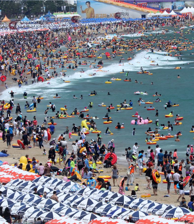 南韓今年也是個酷暑，文在寅總統5月初就任以來已多次限電，卻引發廢核的陰謀論。圖為7月30日釜山的渡假勝地海雲台擠滿了戲水人潮。（東方IC）