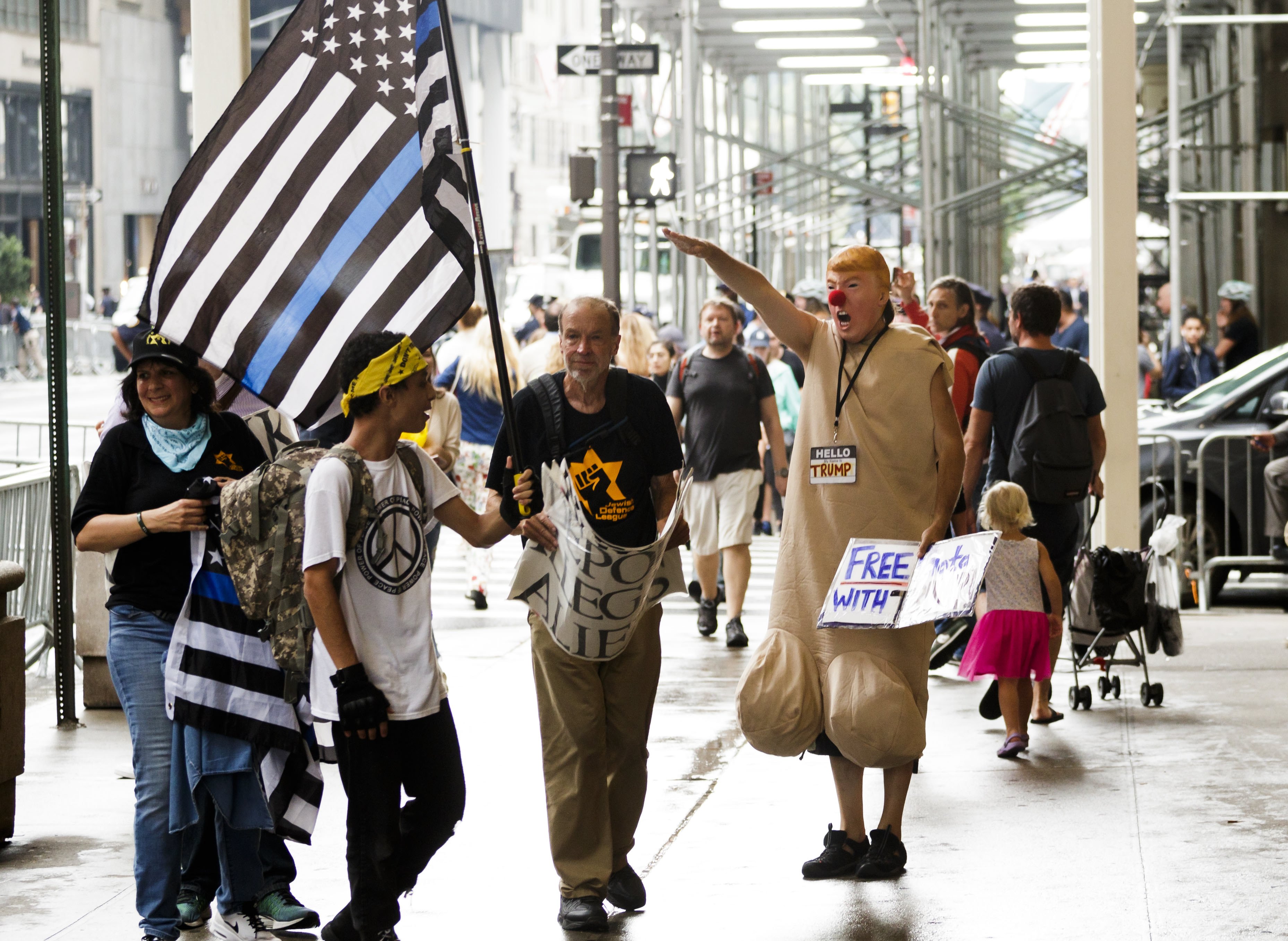 2017年8月15日,紐約川普大樓外帶著川普面具的民眾對著川普的支持者做出充滿嘲諷意味的納粹式敬禮。(東方IC)