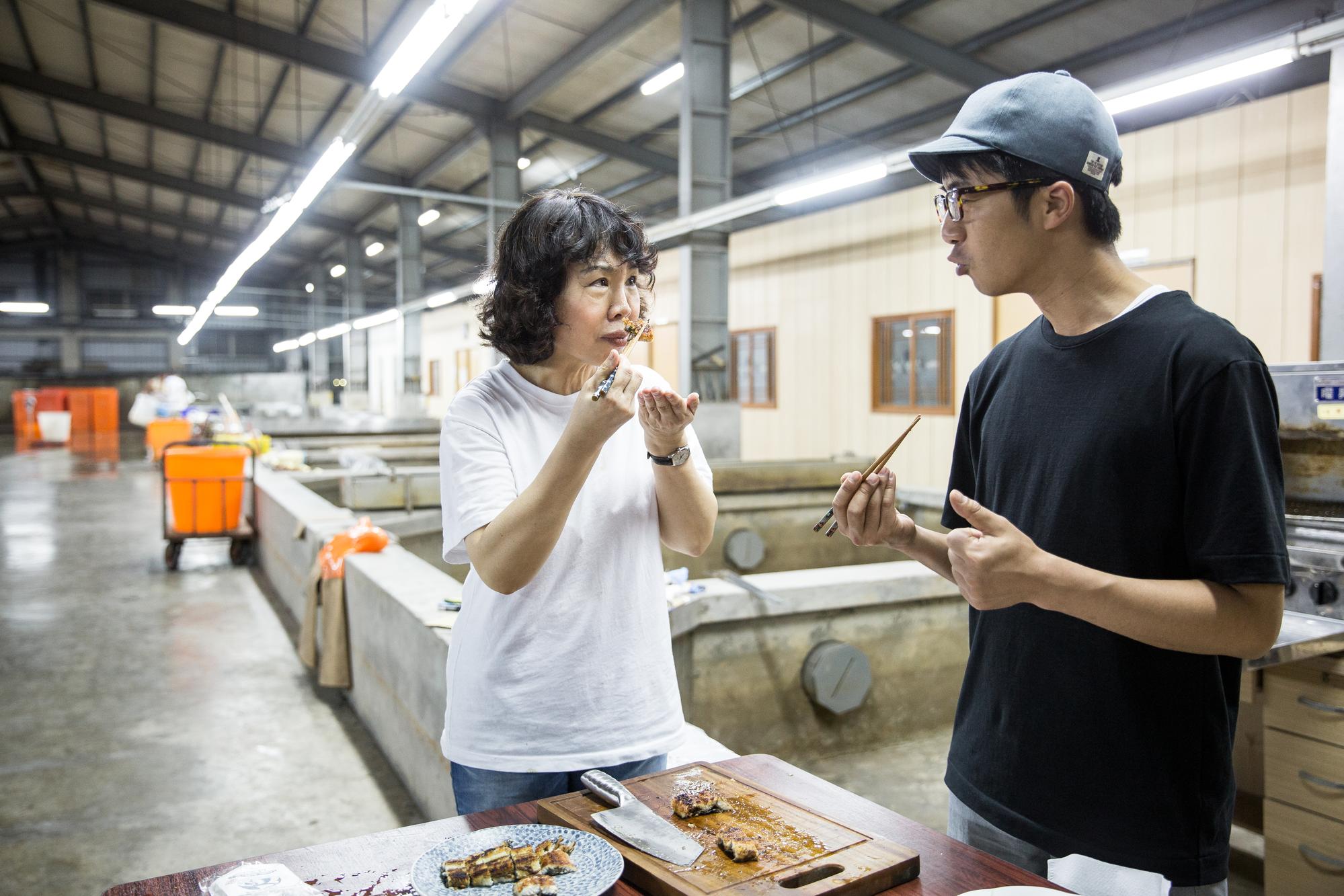 日本九州百年鰻魚名店「田舍庵」第4代傳人緒方大(右)到旺生包裝廠試魚。