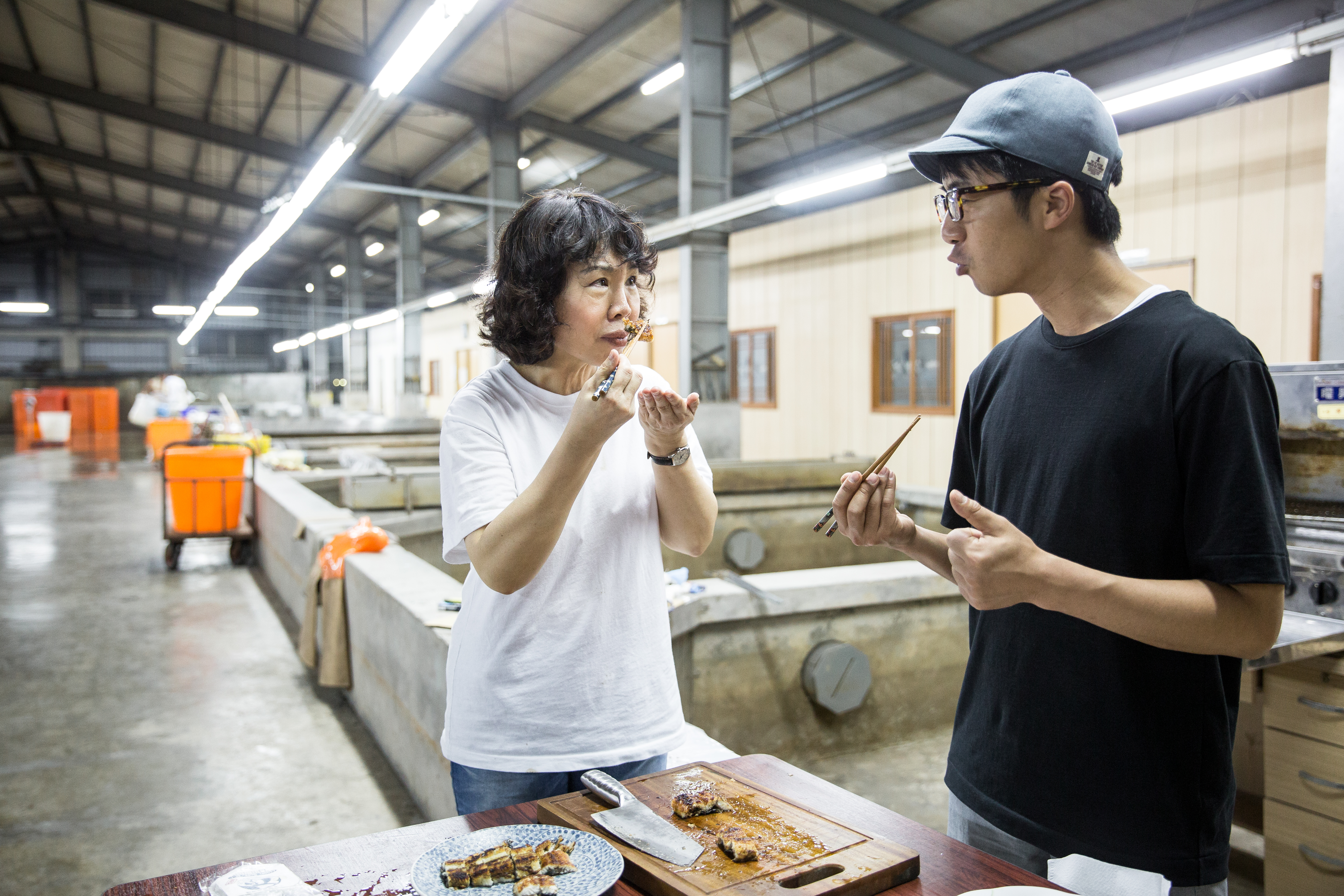 日本九州百年鰻魚名店「田舍庵」第4代傳人緒方大(右)到旺生包裝廠試魚。