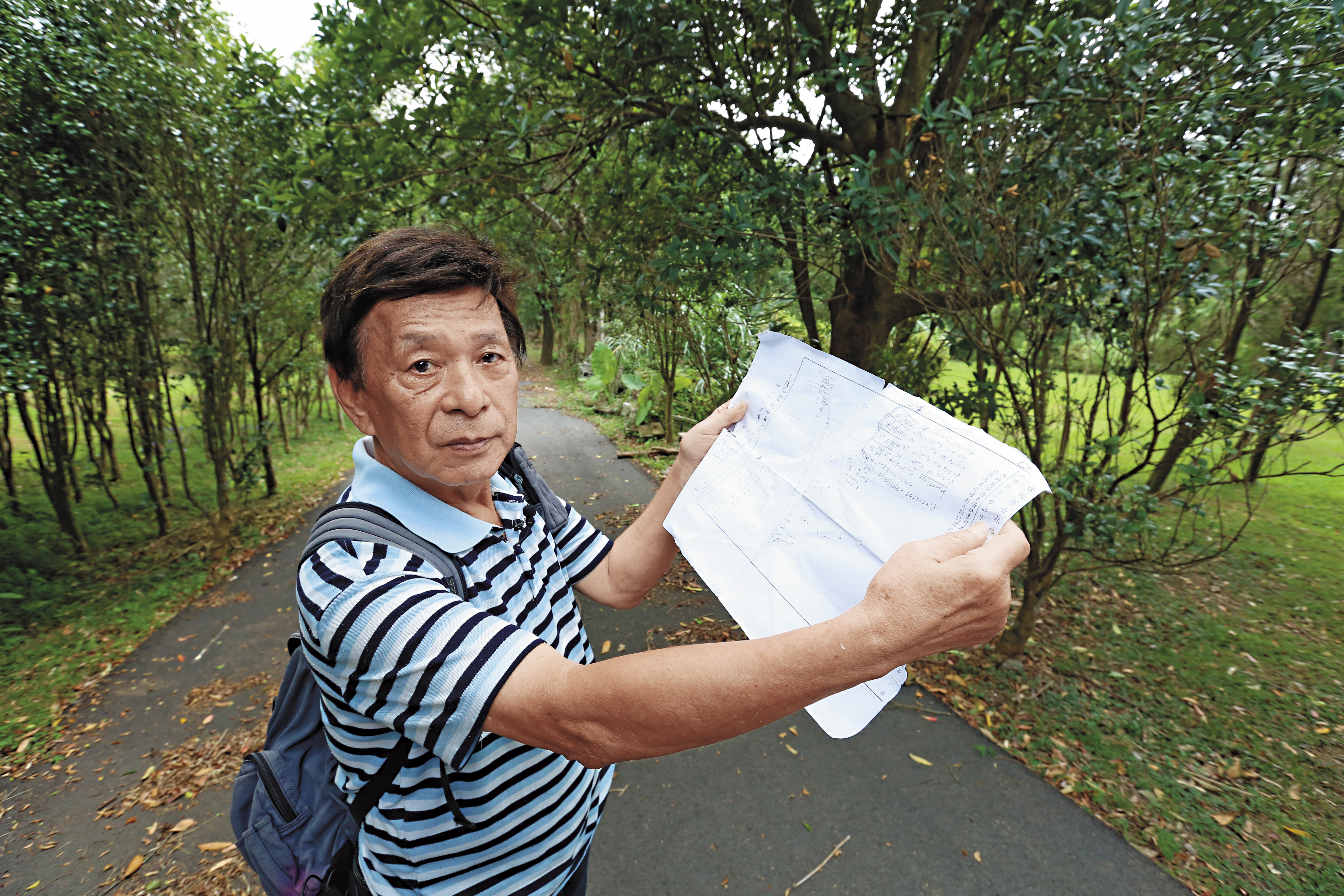 吳政雄拿著地籍圖說，花卉中心名下的這塊土地，原來是吳家所有。