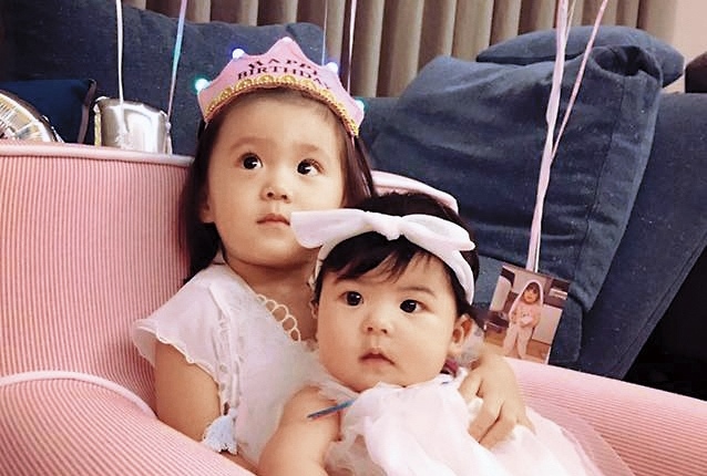 咘咘（左）2歲生日趴，抱著妹妹Bo妞。（翻攝自修杰楷臉書）