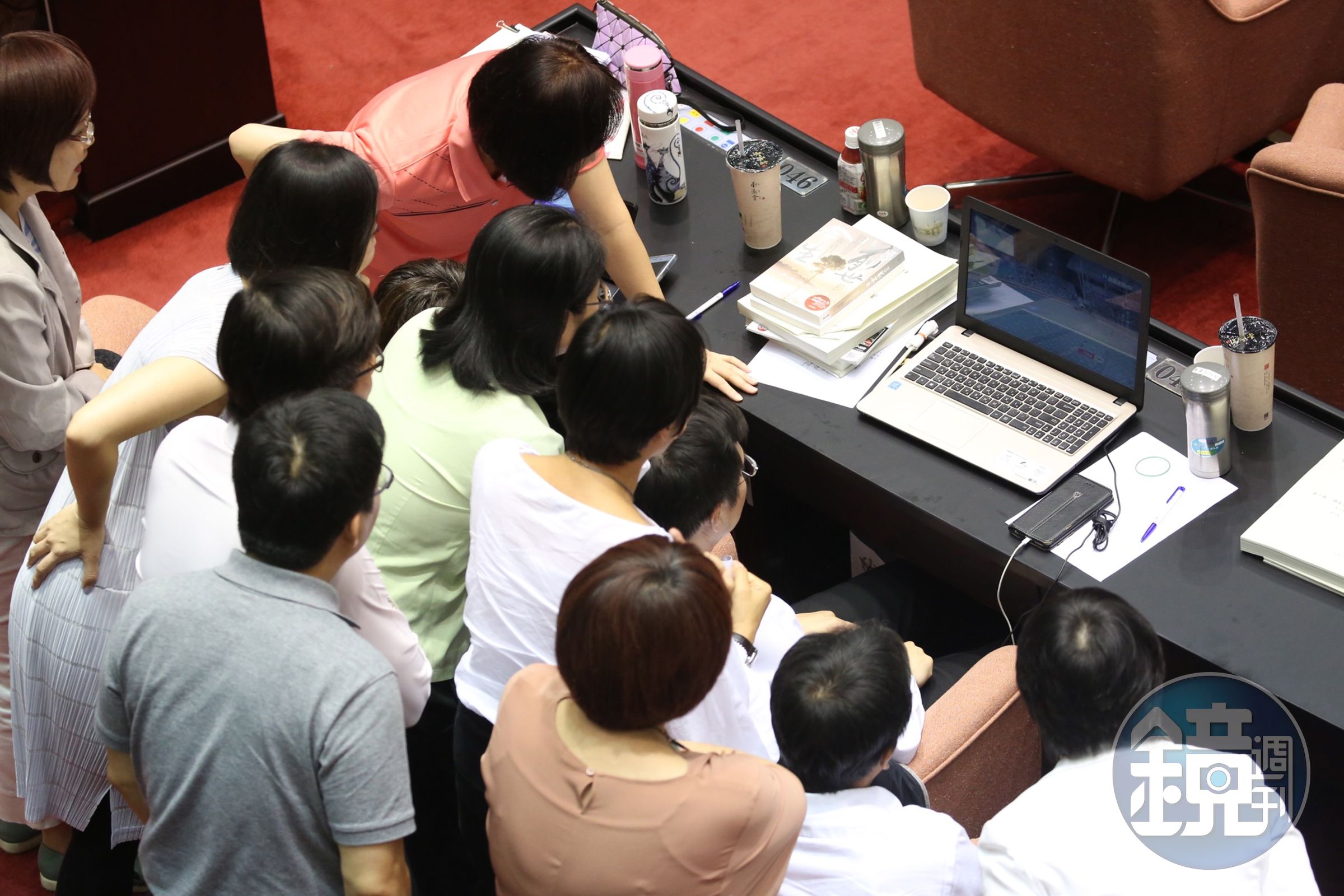 晚間世大運田徑賽男子1600公尺接力登場時，多位民進黨立委圍在正在看直播的民進黨立委羅致政身後觀看比賽。
