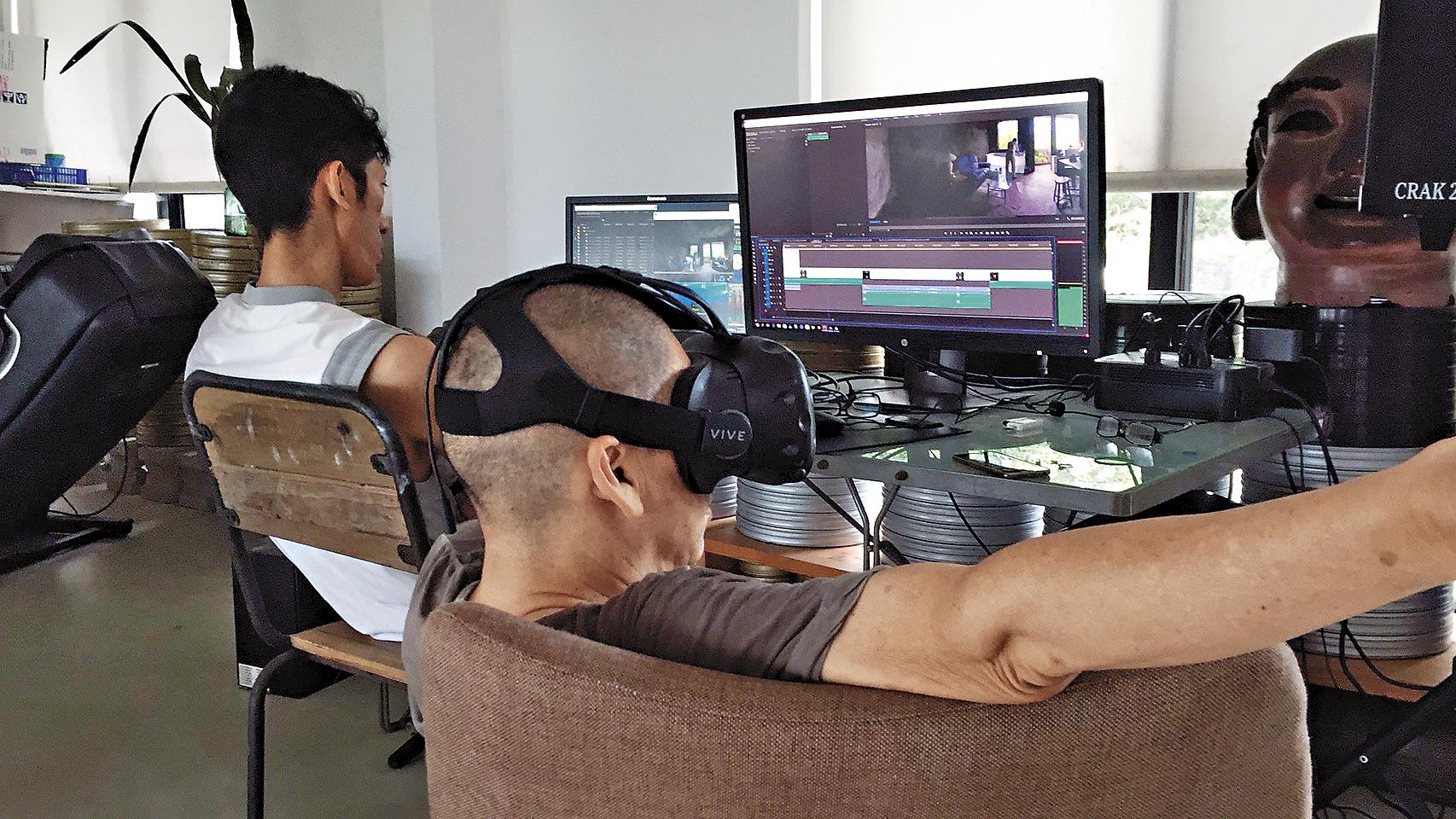 蔡明亮以頭戴顯示器,觀看VR影片,進行後製。(汯呄霖電影提供)