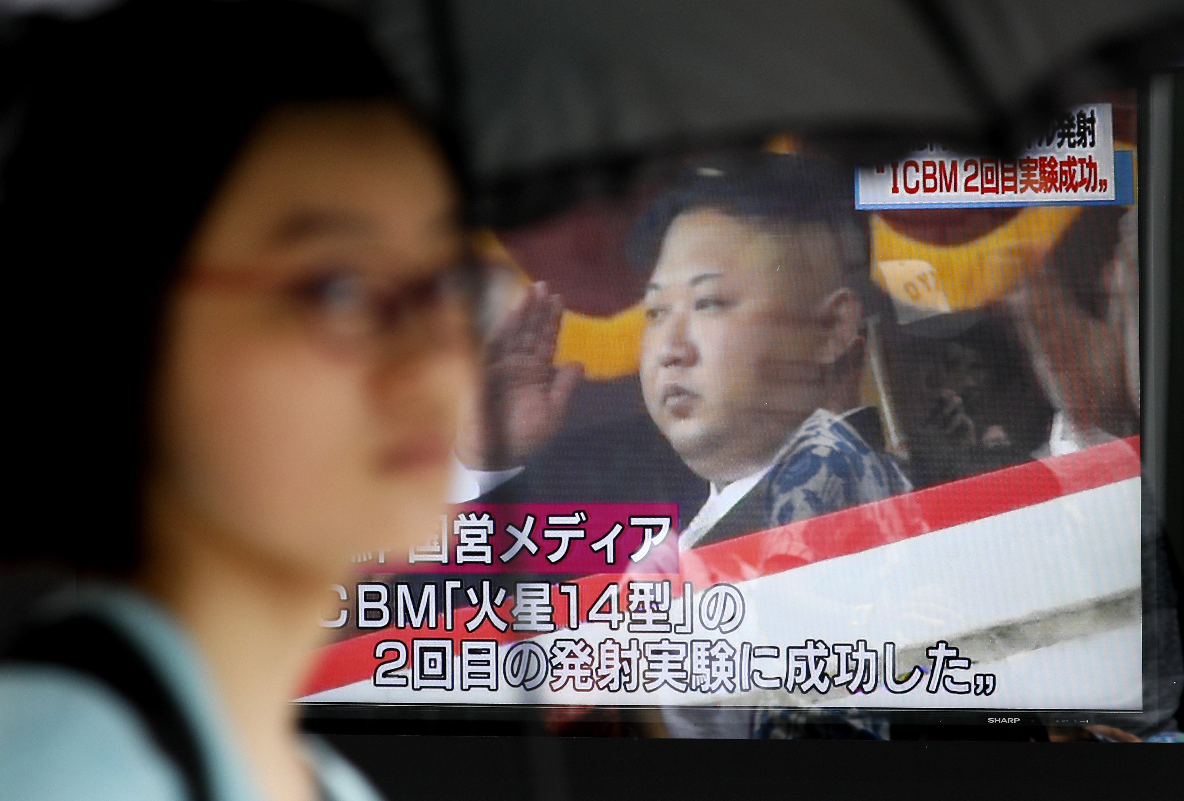 2017年7月29日，日本東京街頭，行人經過的電視螢幕正播放北韓試射導彈落入北海道外海，日本經濟海域範圍內。（東方IC）