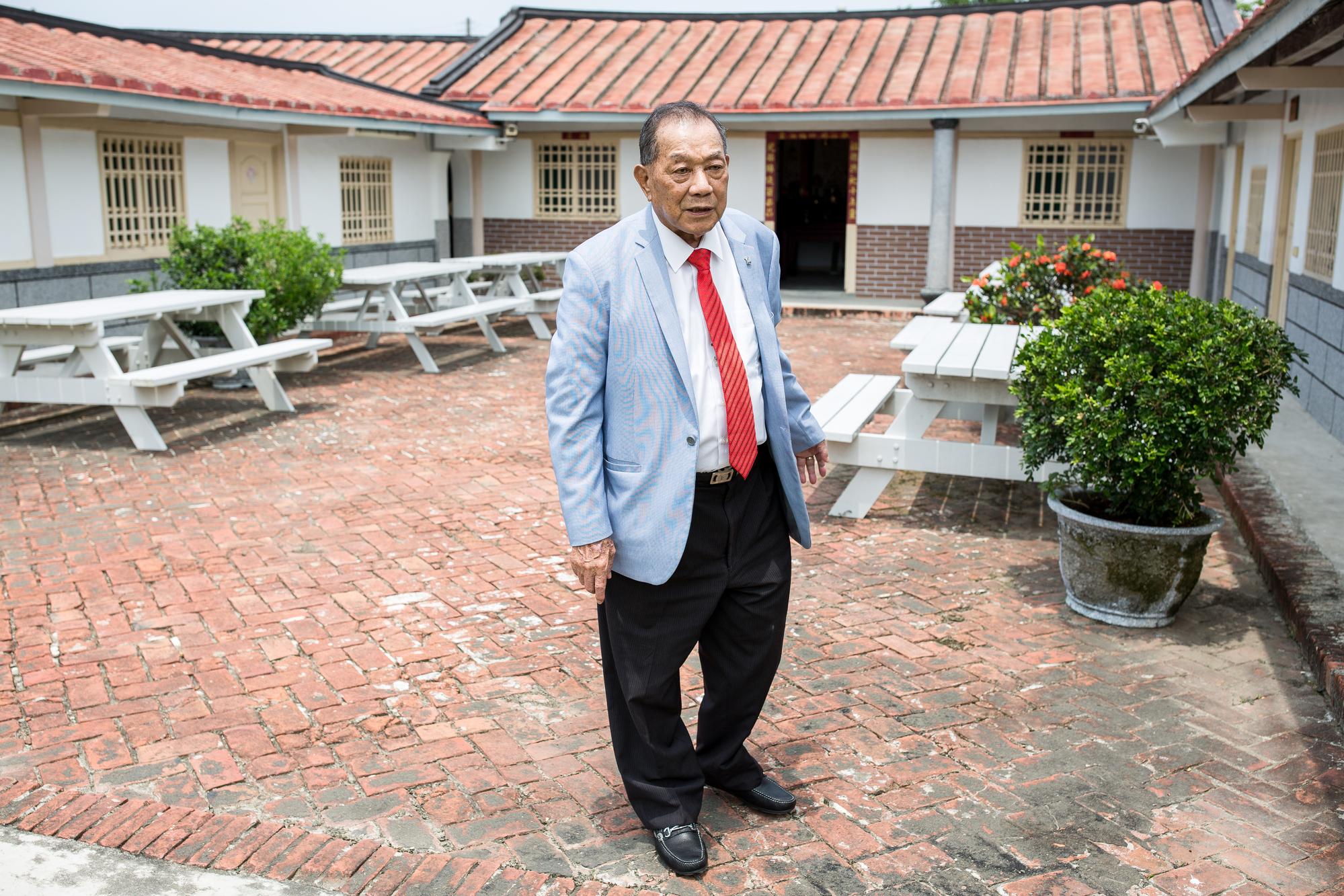 儘管已經83歲了，戴榮吉穿著天藍色西裝、繫上鮮紅色領帶，顯得精神奕奕。