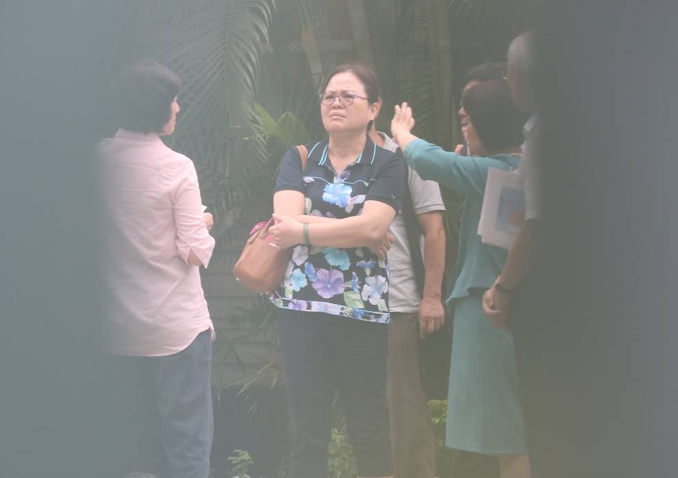 吳玫如(著粉色上衣者)與陳美伶(著套裝者)一起站在官邸房舍外的中庭討論相關事宜。