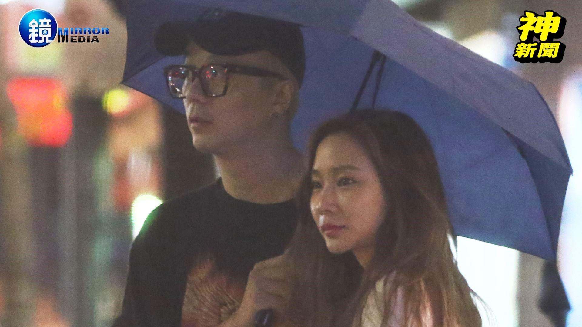 廖人帥和D奶妹在街頭共撐一把傘。