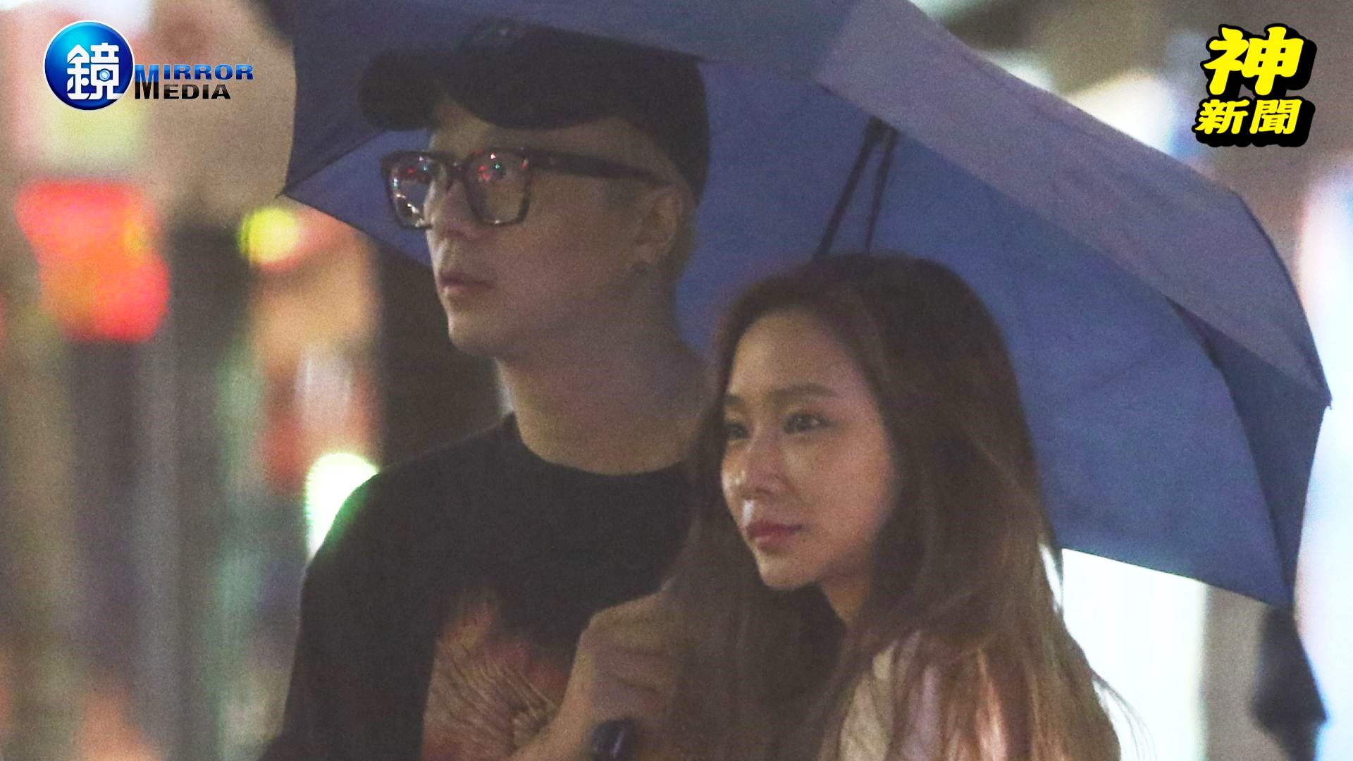 廖人帥和D奶妹在街頭共撐一把傘。