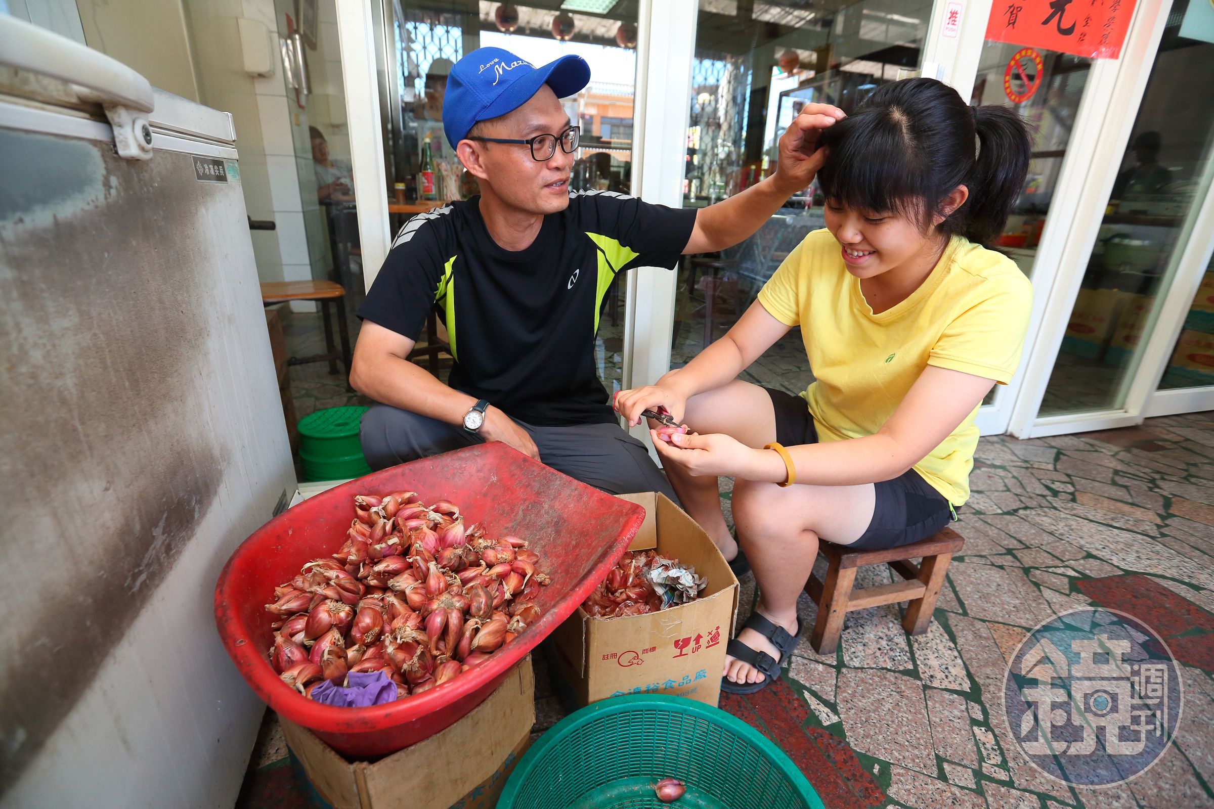 蕭凱嶸（左）的小女兒蕭寶茹（右），課餘時間幫忙剪紅蔥頭。